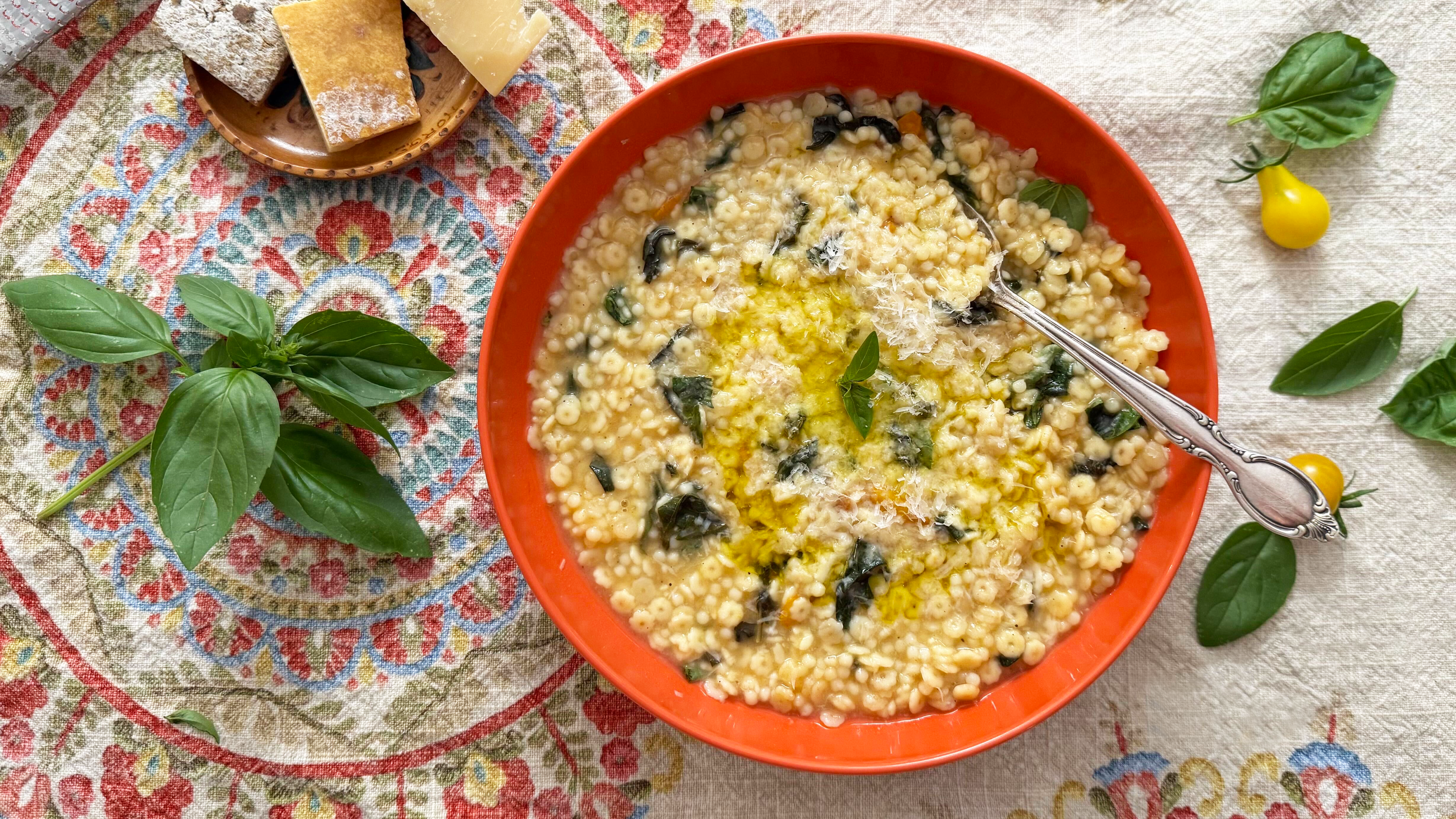 This summery pastina with basil and cherry tomatoes gets extra flavor from a "broth" of basil stems and a Parmesan cheese rind.