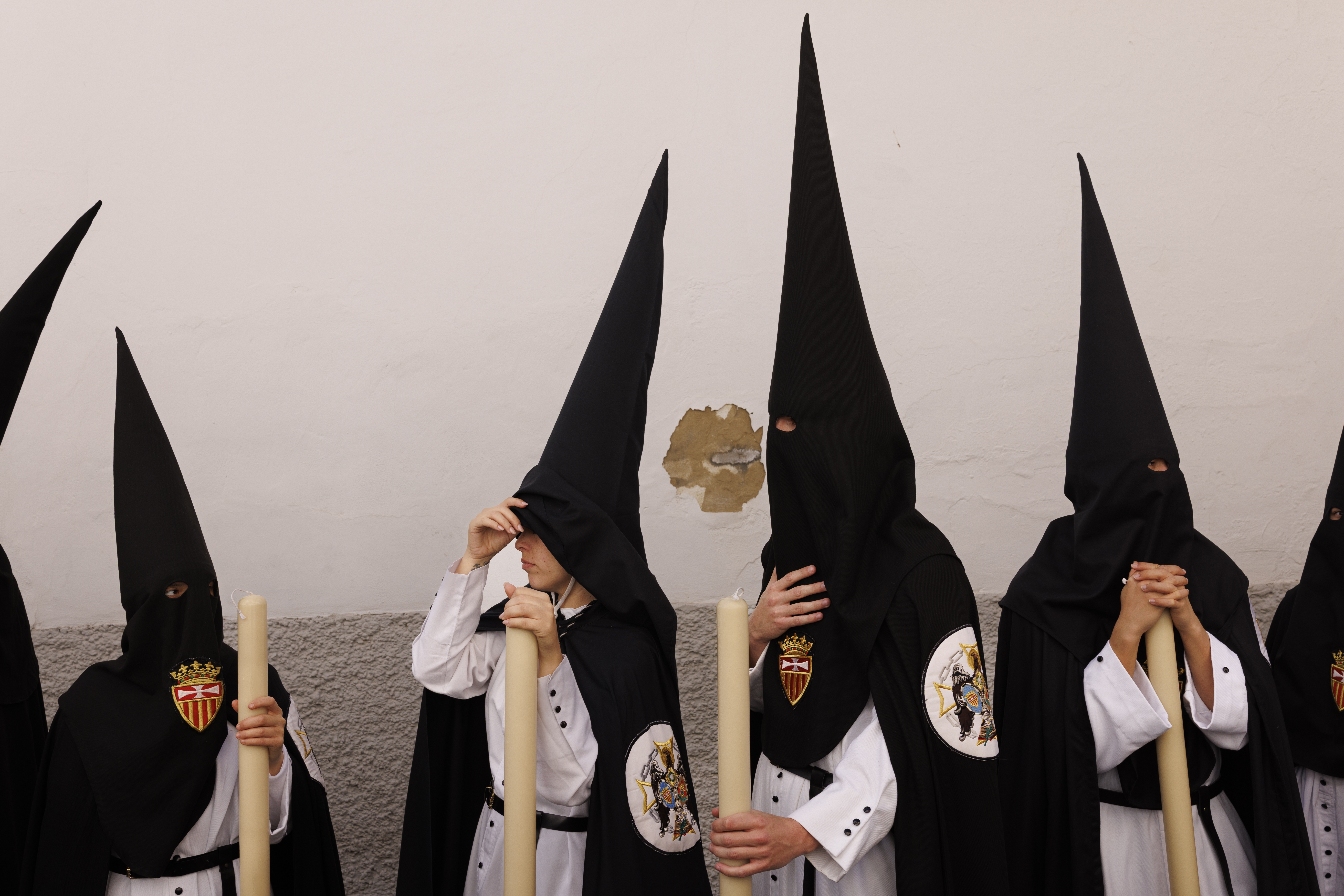 Penitents of Santa Genoveva brotherhood wait before taking part in a procession during Holy Week (Semana Santa) observances on March 30, 2026 in Seville, Spain.