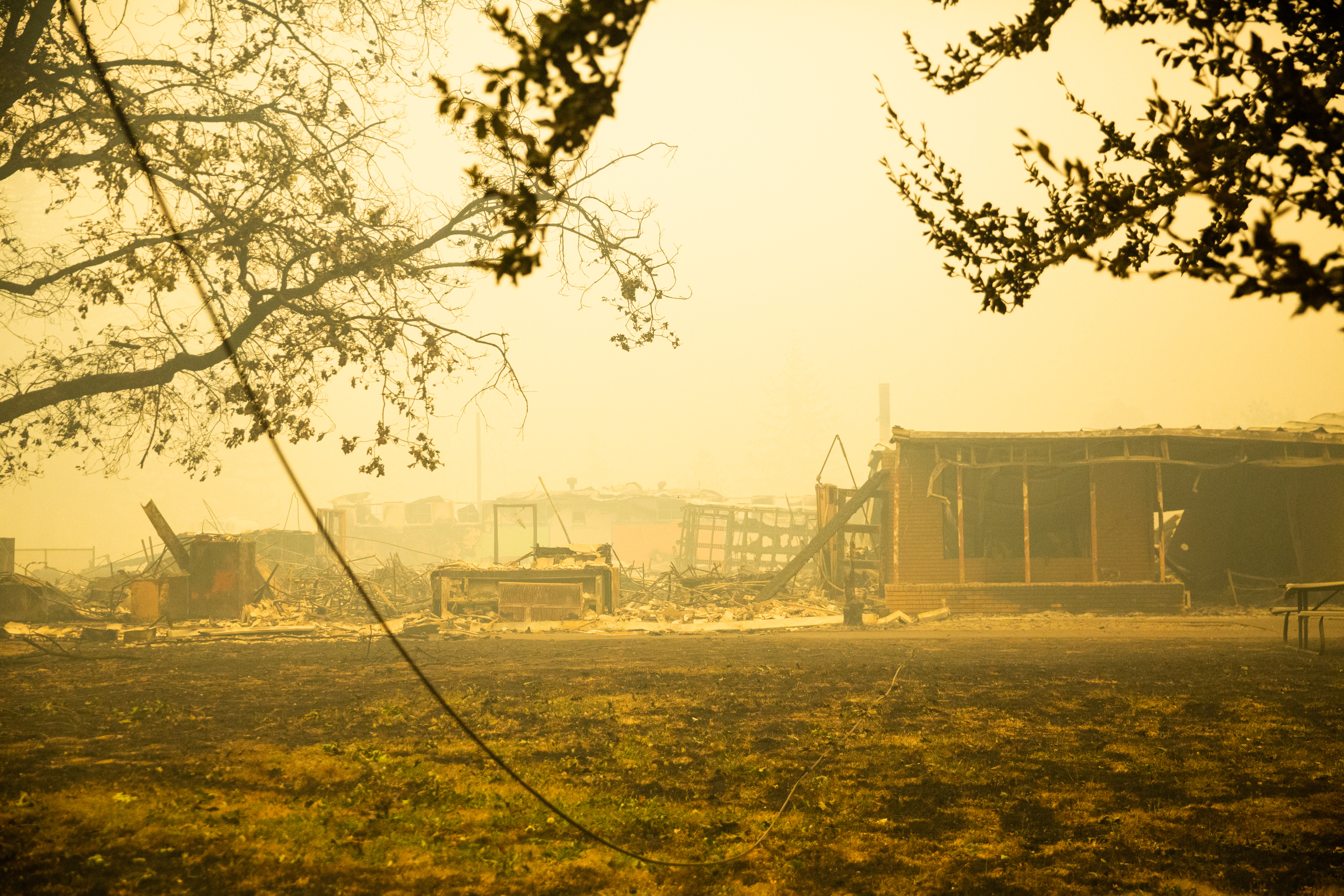 FILE - A downed line runs to the burnt remains of a building near Gates, Ore., Sept. 9, 2020. The case accusing utility PacifiCorp of starting the 2020 Labor Day fires in Oregon has gone to jury.