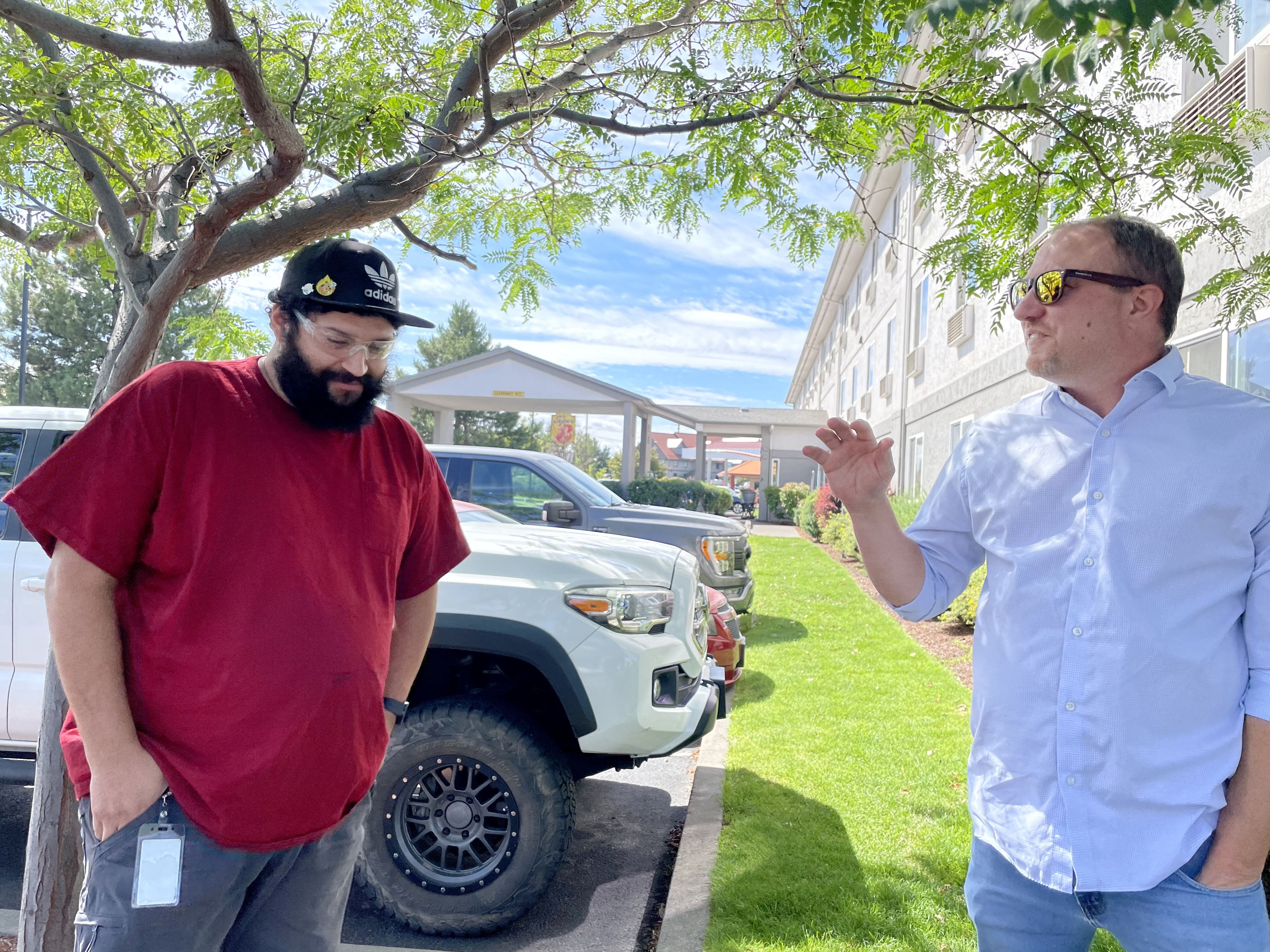 FILE-Kevin Wilson, left, talks with Rick Russell, a pastor at Mountain View Fellowship and the director of Redmond’s Safe Parking program. The program helps vetted participants park their vehicles at designated sites overnight and assists people like Wilson, who struggled with houselessness before recently moving into an apartment.