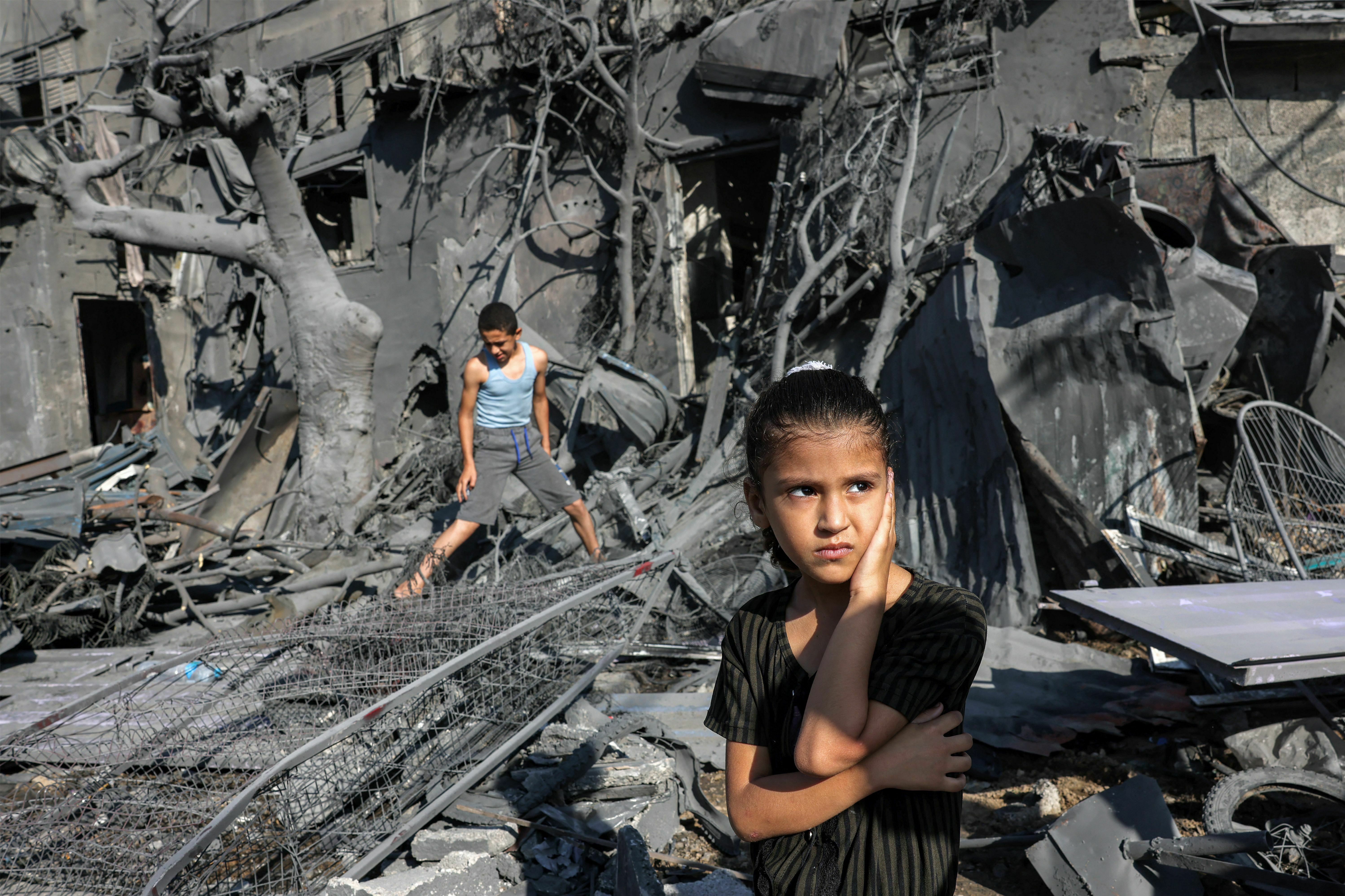 A girl looks on as she stands outside a building that was hit by Israeli bombardment in Rafah in the southern Gaza Strip.