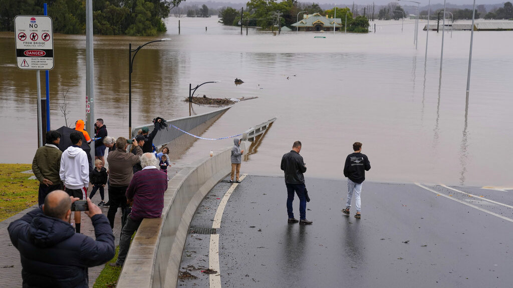 People look Tuesday at the flooded Windsor Bridge at Windsor on the outskirts of Sydney, Australia.