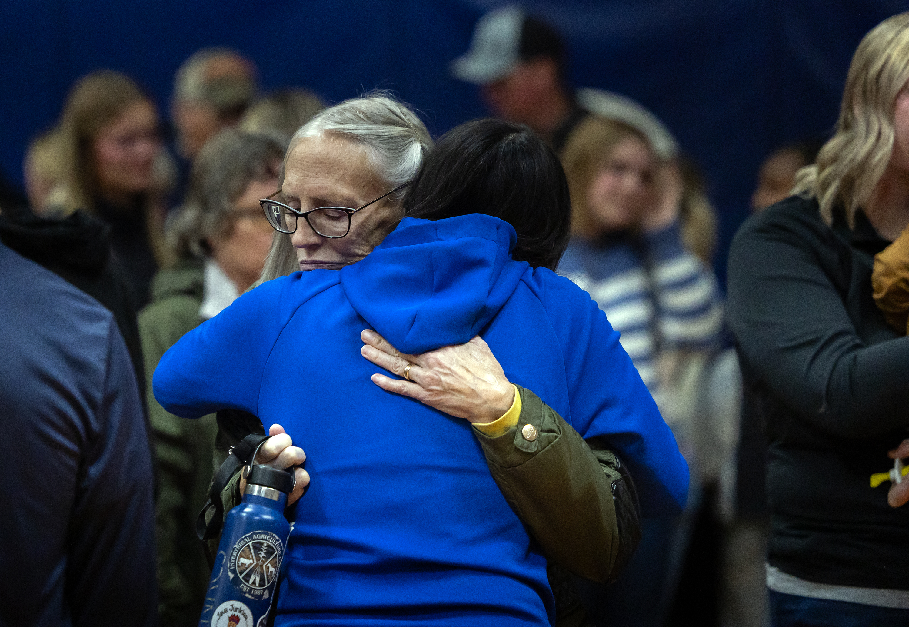 Vigil attendees embrace each other.
