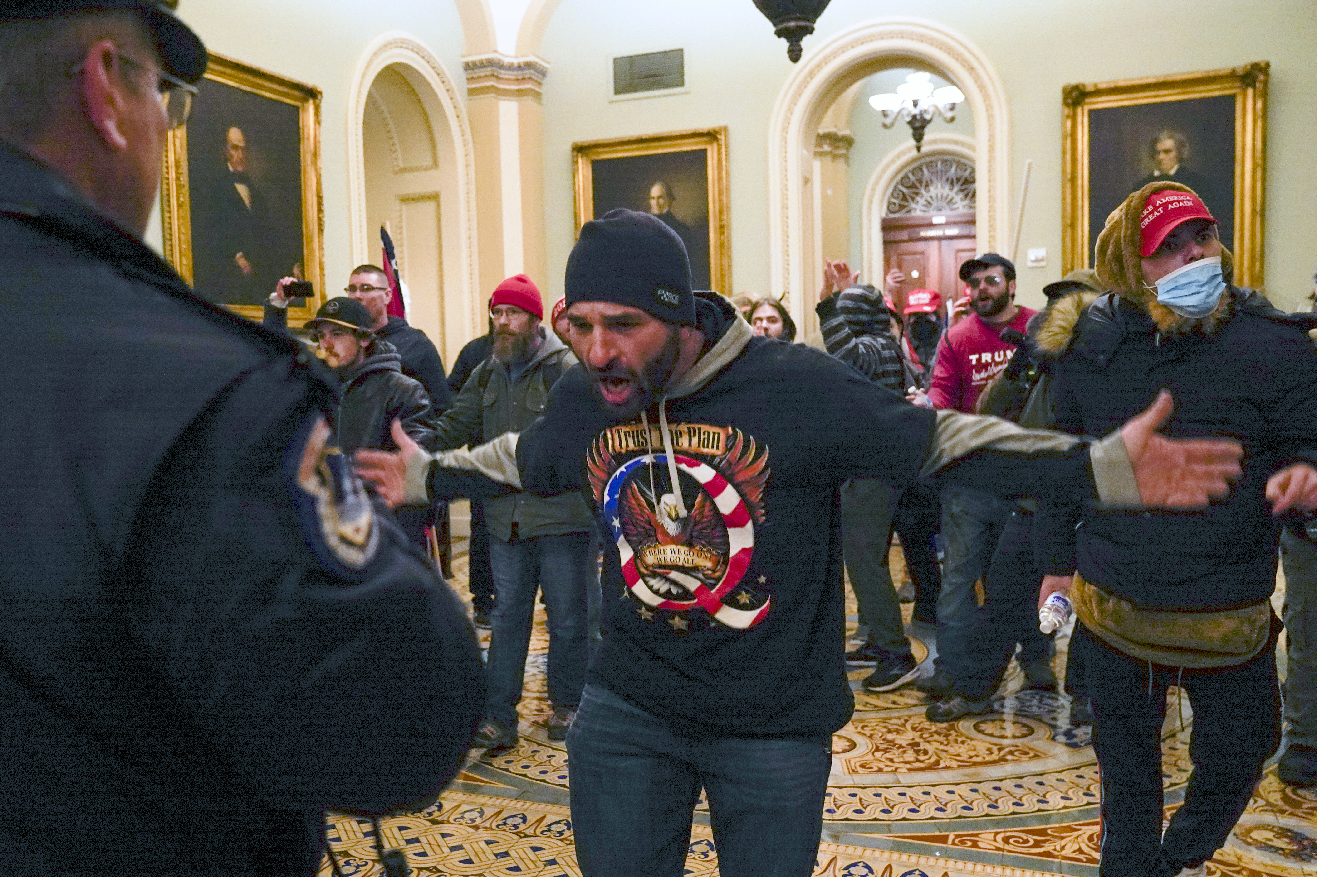 In this Jan. 6, 2021, file photo, Trump supporters gesture to U.S. Capitol Police in the hallway outside of the Senate chamber at the Capitol in Washington. Doug Jensen, an Iowa man at center, was jailed early Saturday, Jan. 9, 2021 on federal charges, including trespassing and disorderly conduct counts, for his alleged role in the Capitol riot. Jensen, 41, of Des Moines, was being held without bond at the Polk County Jail and county sheriff's Sgt. Ryan Evans said he didn’t know if Jensen had an attorney.