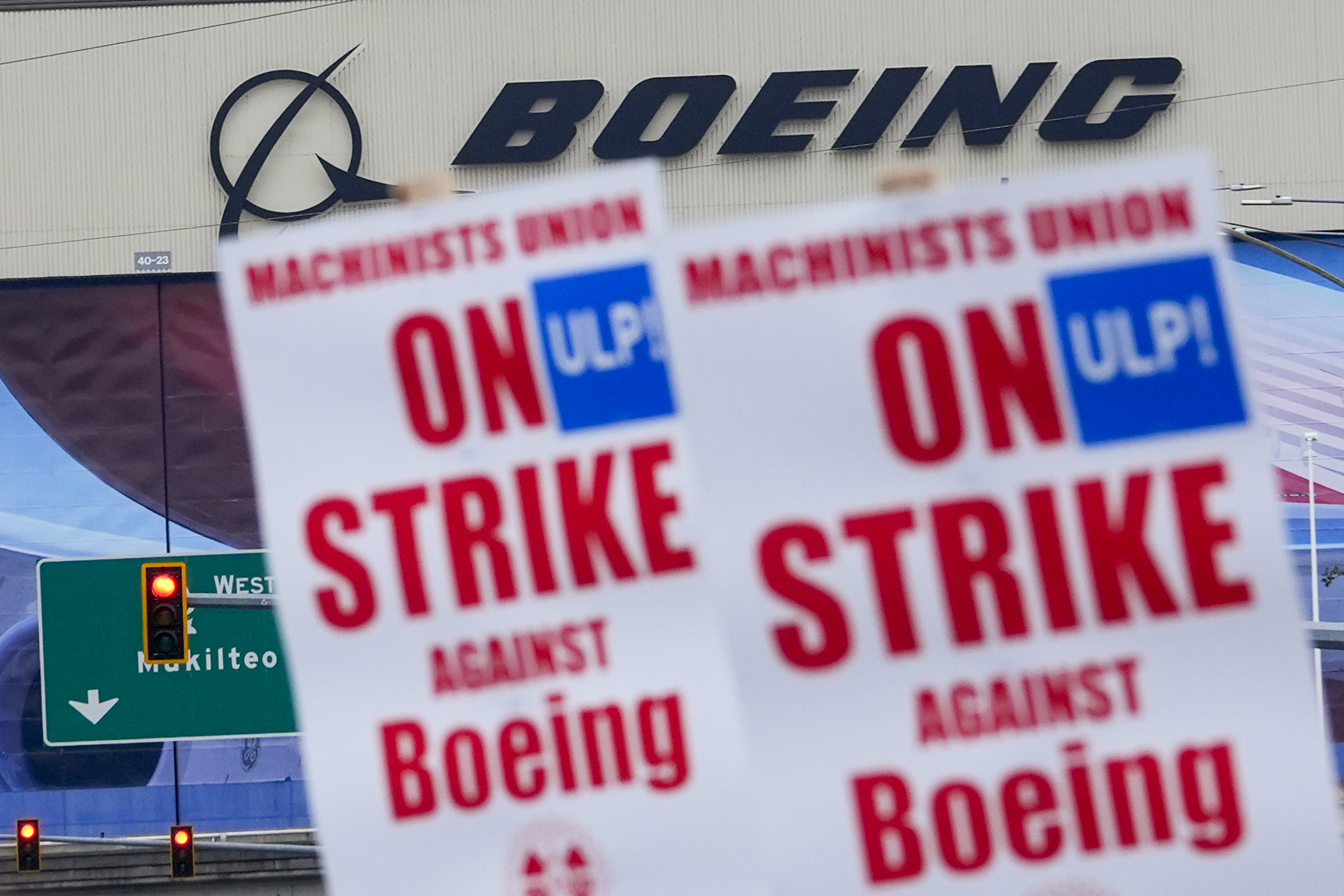 Boeing workers wave picket signs as they strike after union members voted to reject a contract offer, Sept. 15, 2024, near the company's factory in Everett, Wash. The company on Monday made what it called its "best and final" contract offer to striking machinists.