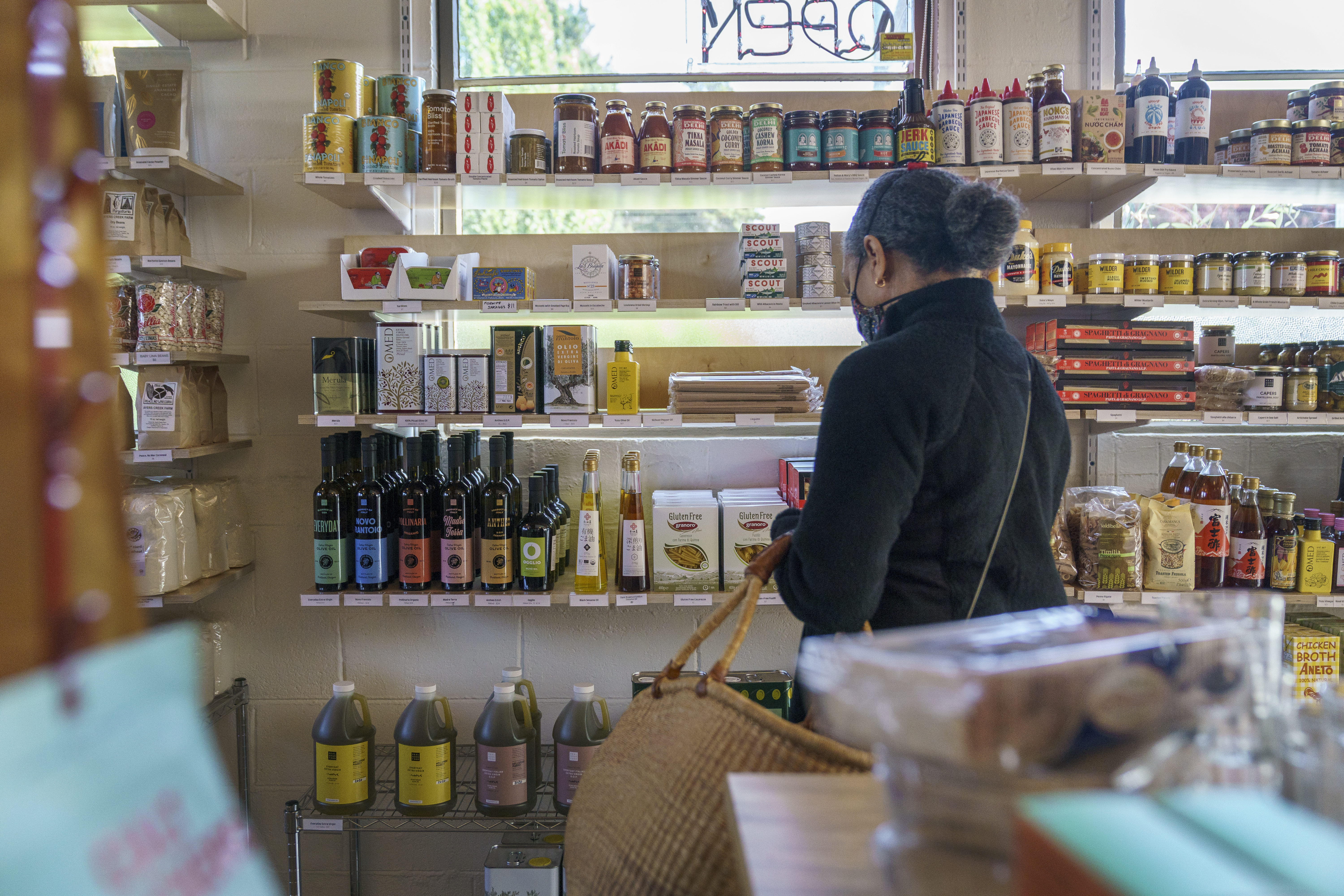 A customer shops at Wellspent Market in Portland. The delay in the store's olive oil delivery from Italy has delayed the launch of a distribution program that would put Wellspent’s olive oil in more local shops. 
