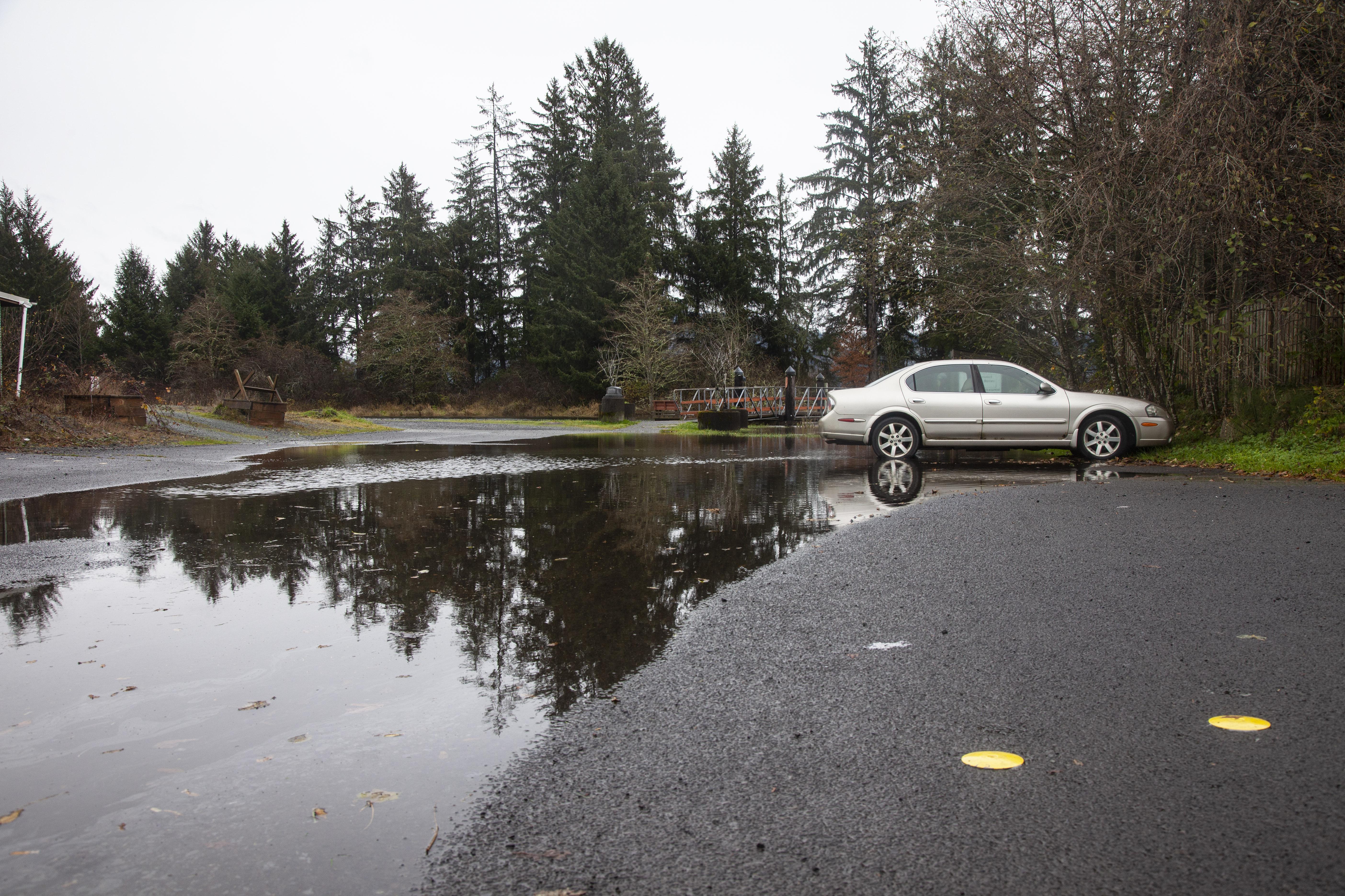 A car sits surrounded by saltwater at the boat ramp in Nehalem, Oregon. When king tides meet heavy rain, the parking lot can fill with over a foot of water.