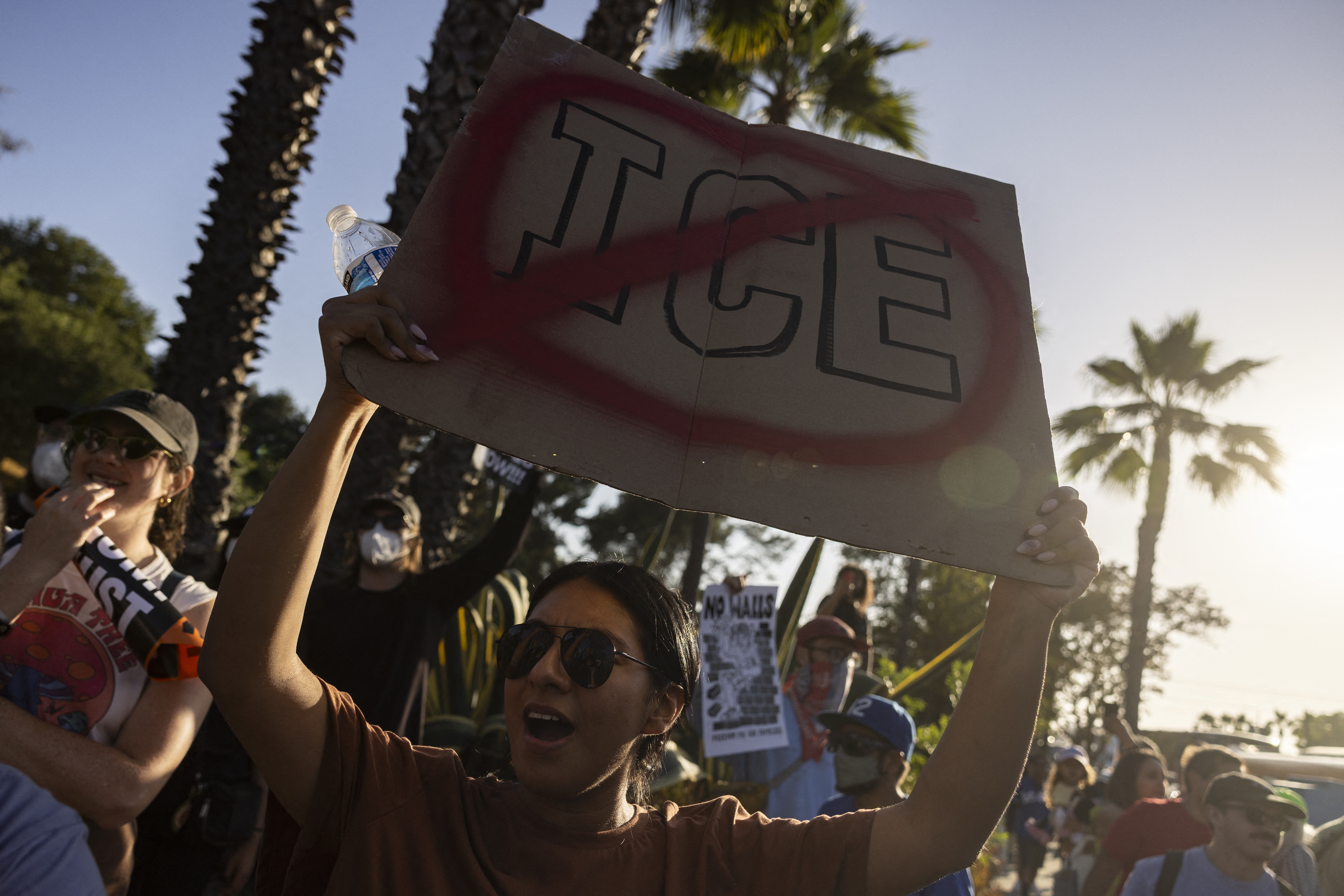 A demonstrator holds up a sign as they protest in front of the main entrance of Dodger Stadium on Thursday.