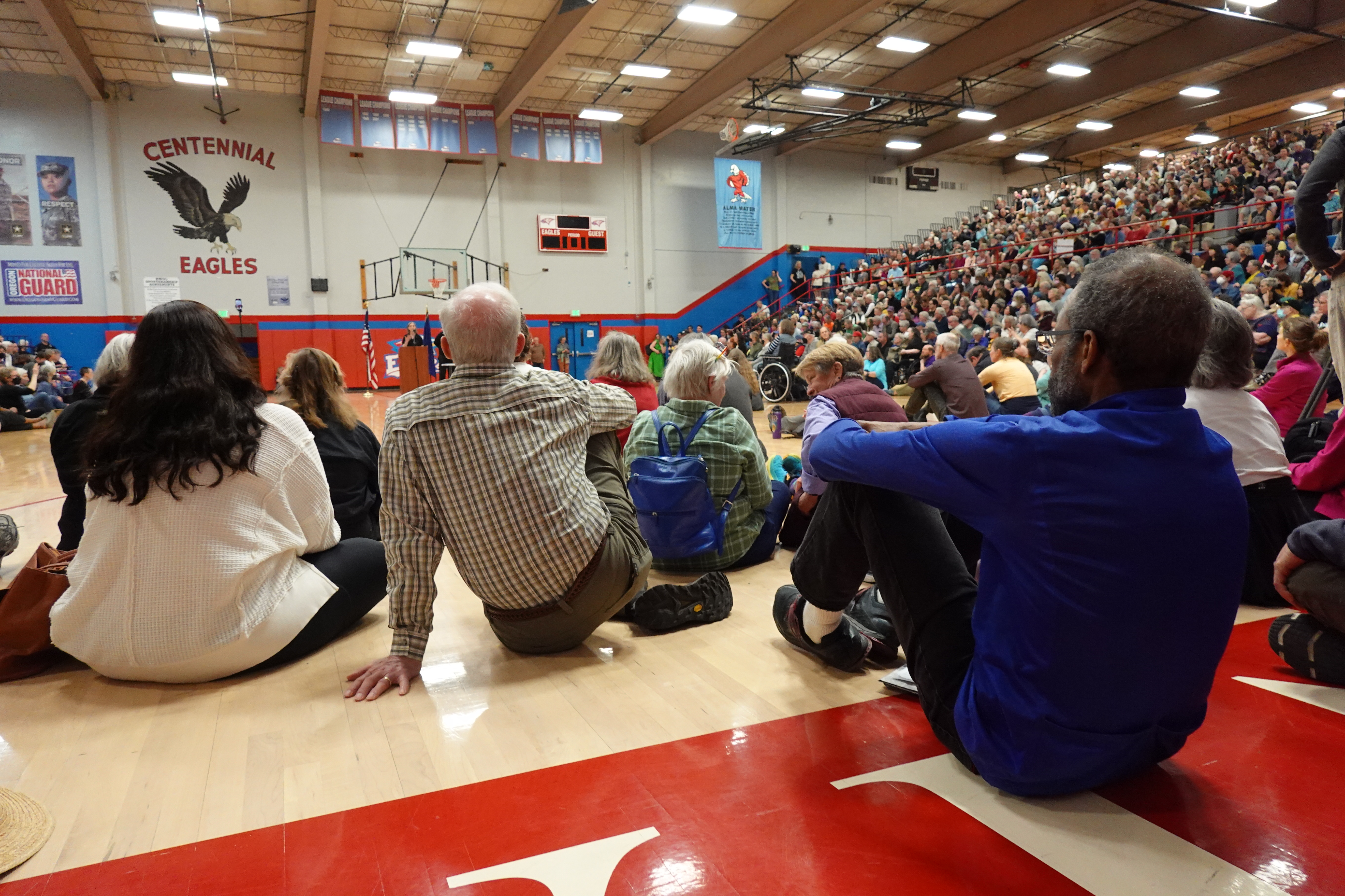 Members of the audience sit on the floor, listening to U.S. Rep. Maxine Dexter. Thousands came to here the freshman representative speak.