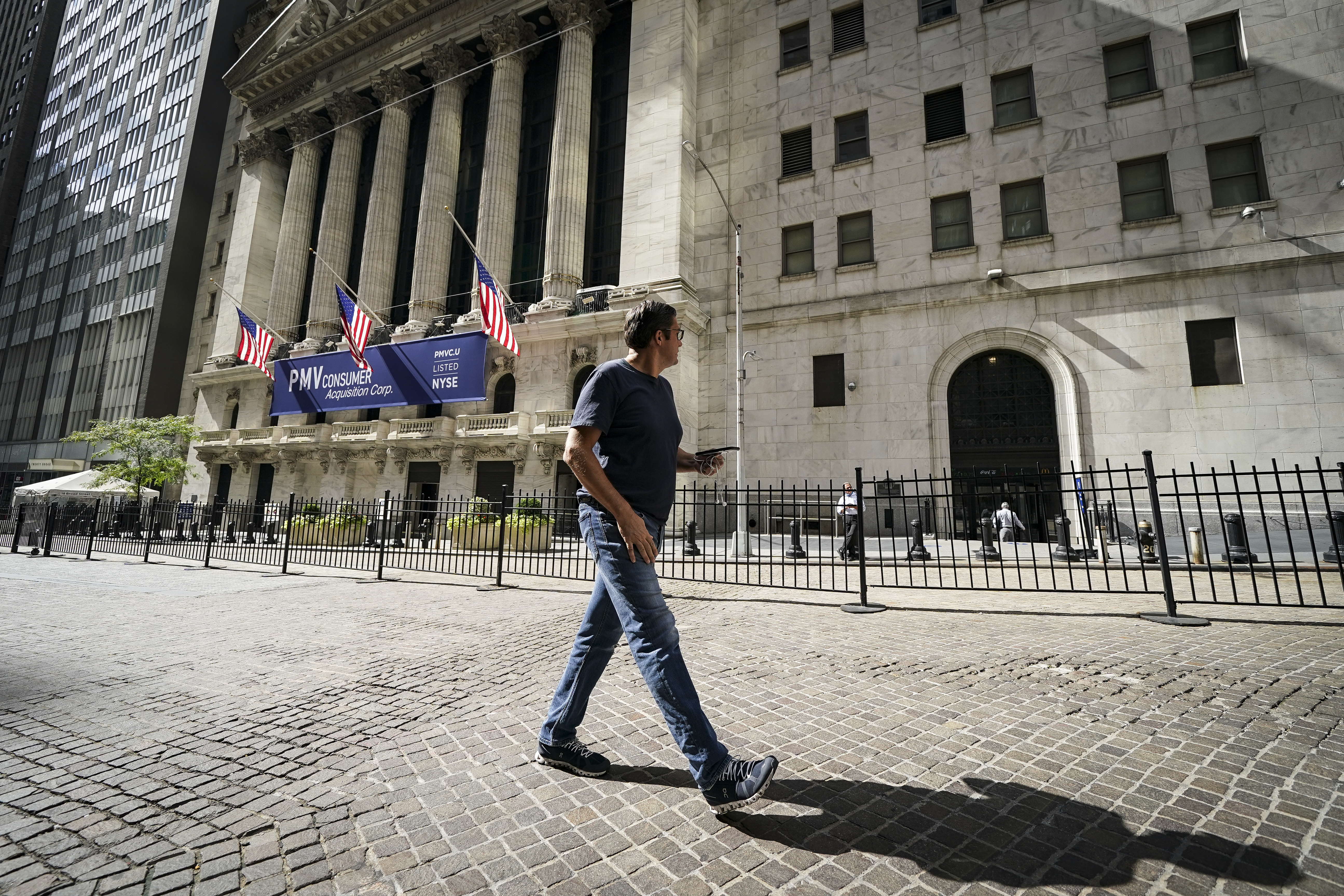A pedestrian walks past the New York Stock Exchange.
