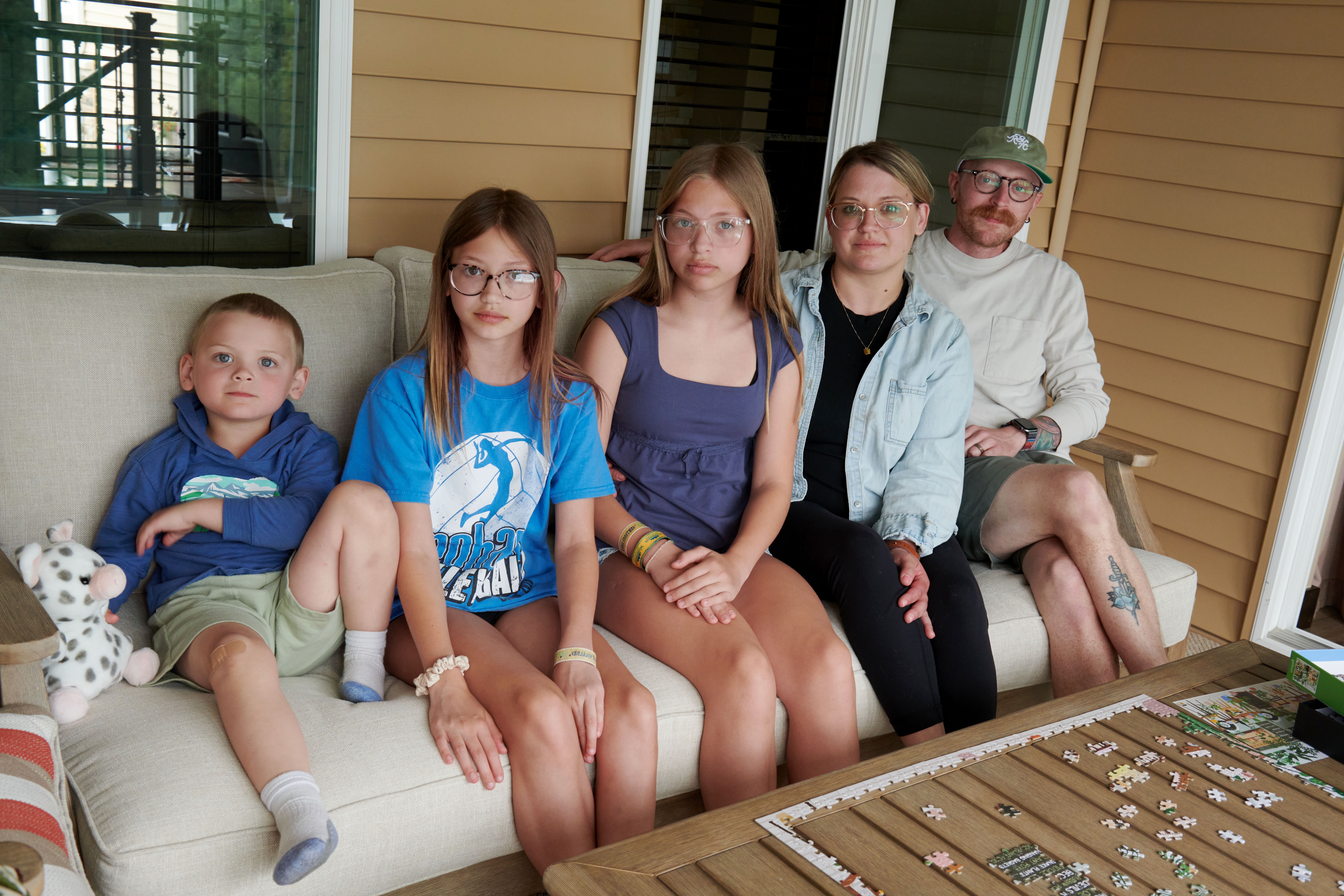 4-year-old Jack Petersen, 11-year-old Eden Svejda, 12-year-old Piper Svejda, Amber Petersen and Neil Petersen pose for a family portrait in Iowa City, Iowa on Sunday, June 14, 2026. The family lives in Mason City, Iowa and was visiting Amber’s parents for the weekend. (Cliff Jette for NPR)