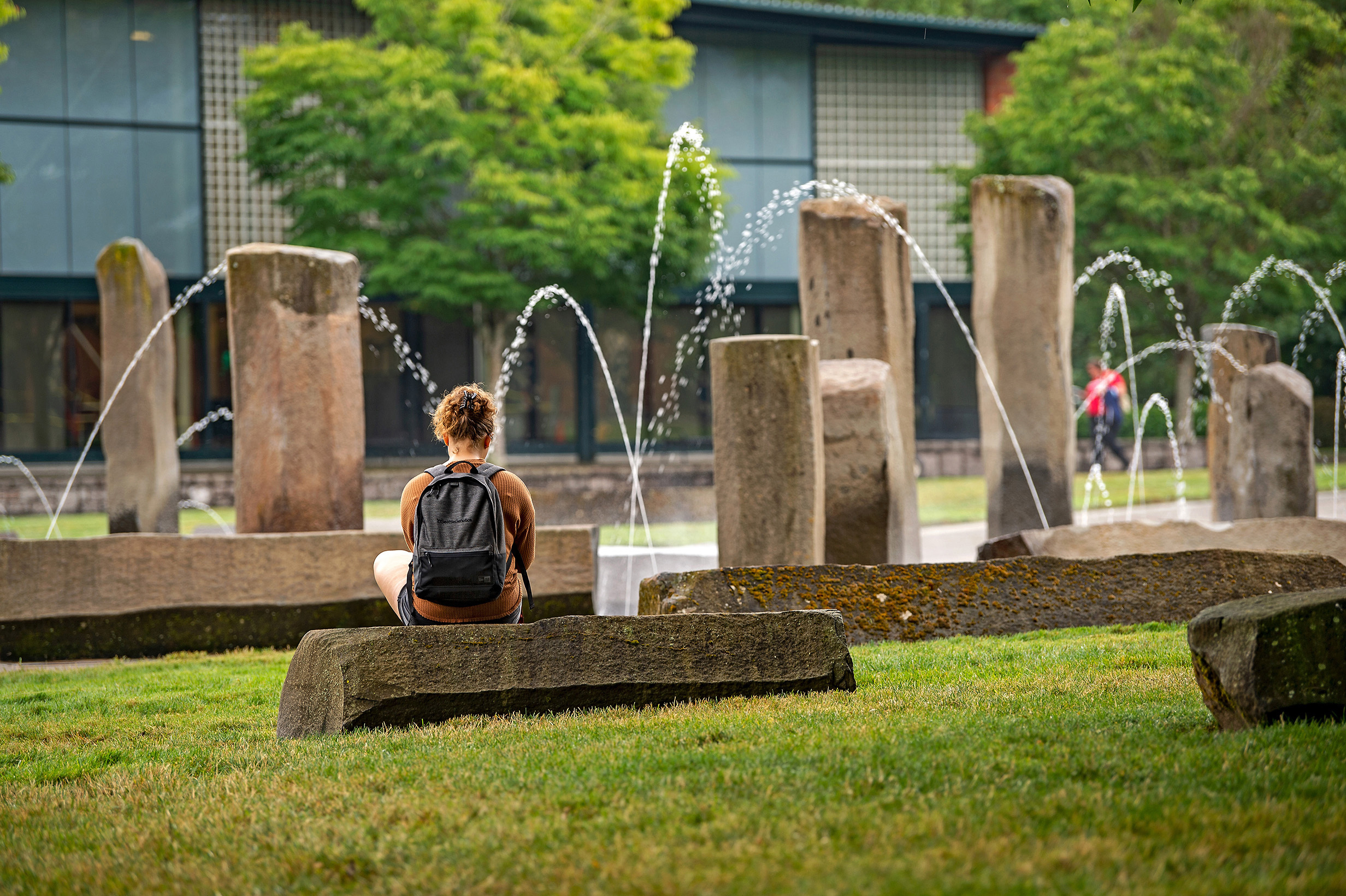 Washington State University Vancouver will feel the brunt of the university system's budget cuts. In this undated, provided photo a student sits on the grounds of the Southwest Washington campus.