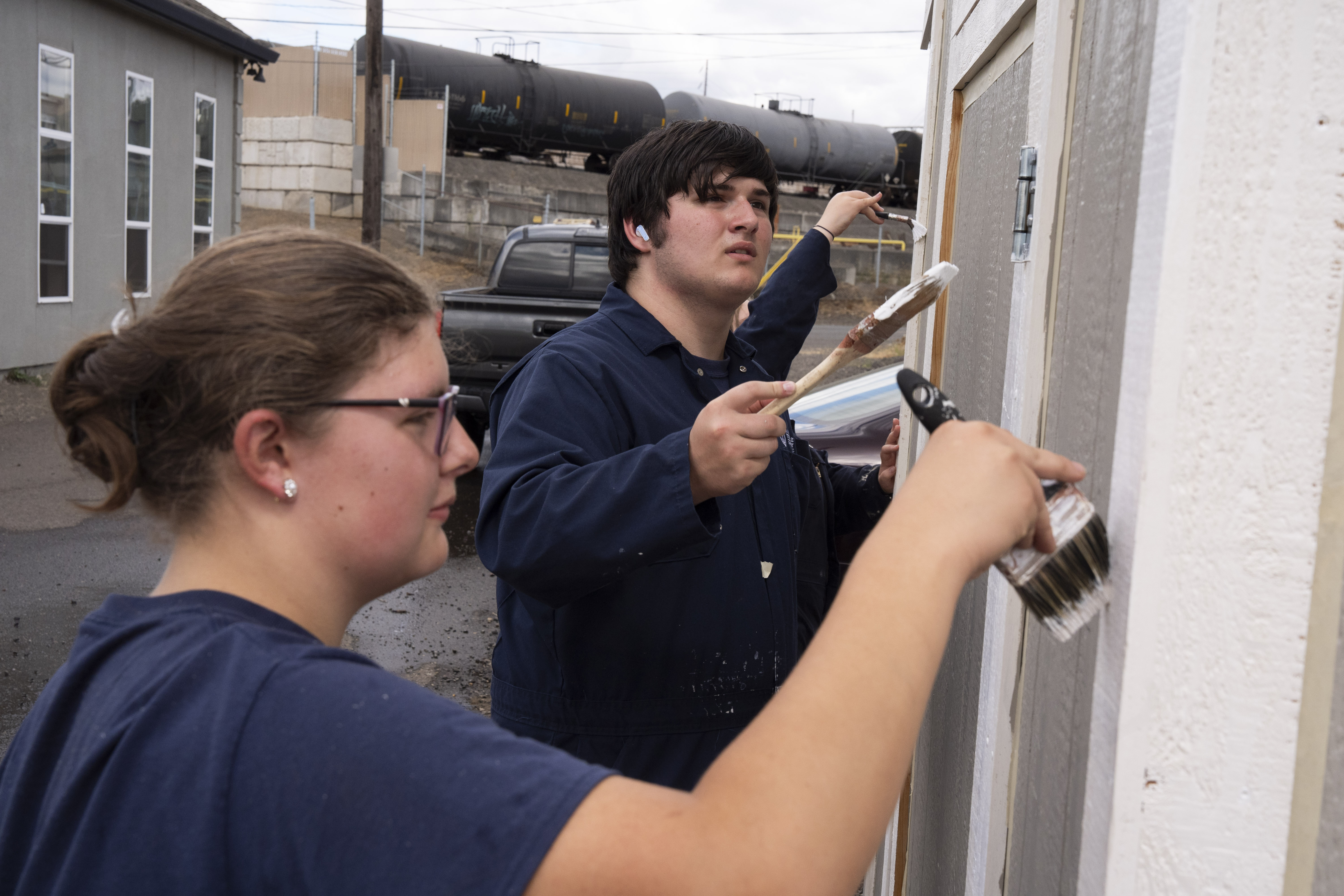 From left, Annabelle Corpuz and Henryk Kaiser paint a shed at the program.