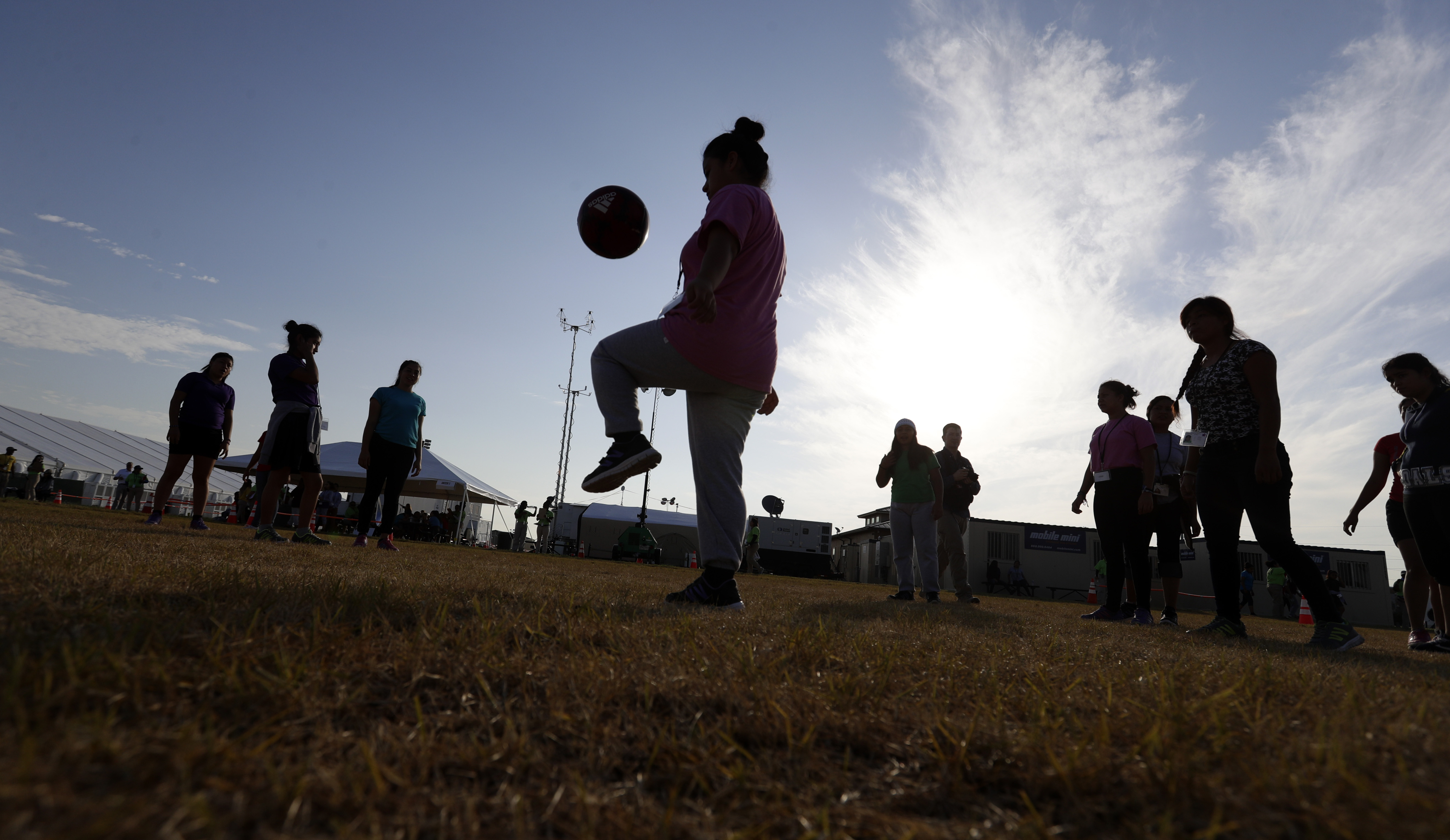 FILE- Immigrants play soccer at the U.S. government holding center for migrant children in Carrizo Springs, Texas, on July 9, 2019. In 2025, Washington launches a state task force to shore up support systems for children whose immigrant parents face deportation.