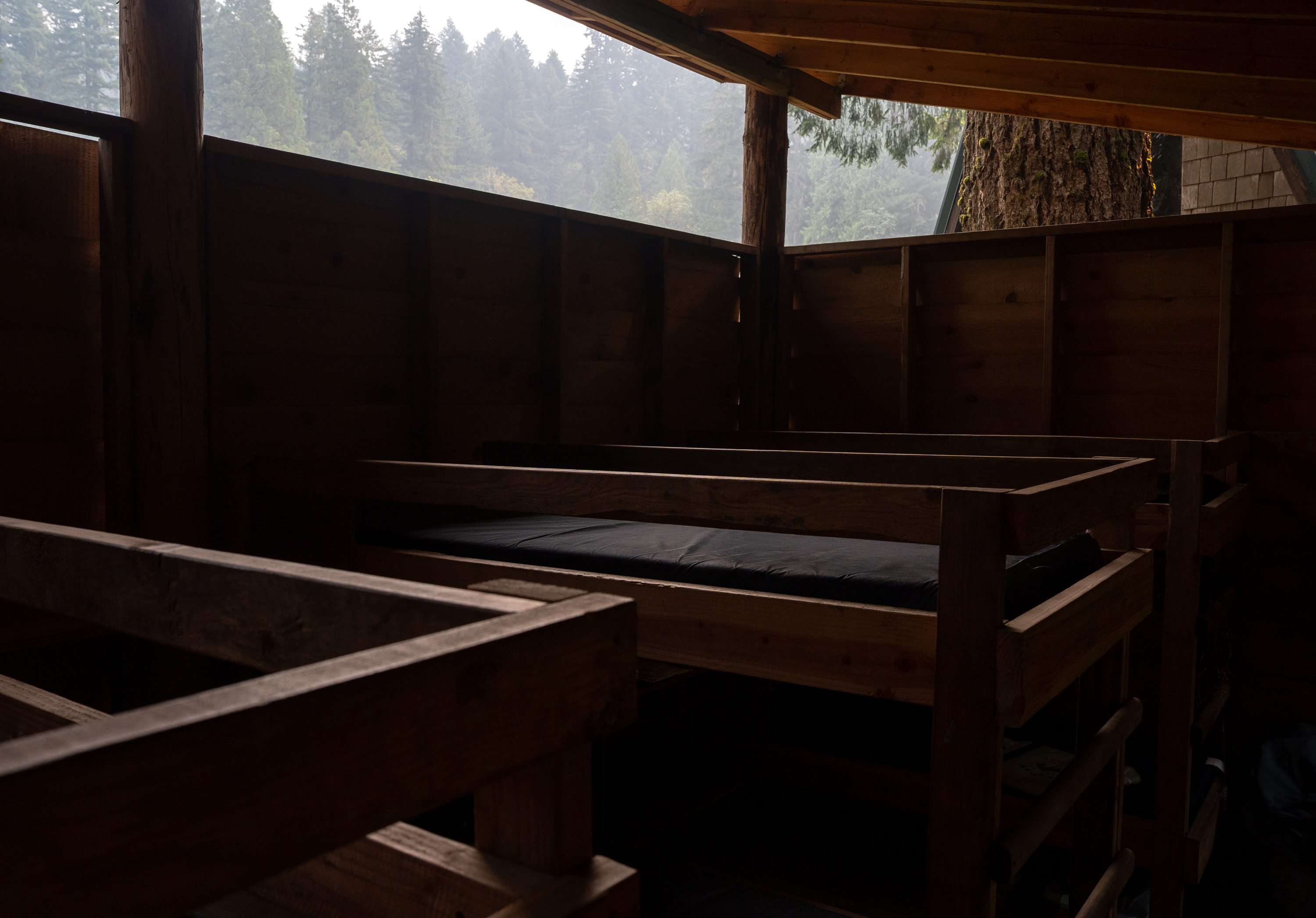 Bunk beds in an open-air cabin lay empty at Camp Namanu, which temporarily closed due to the poor air quality from wildfire smoke, ending a camp session three days early.
