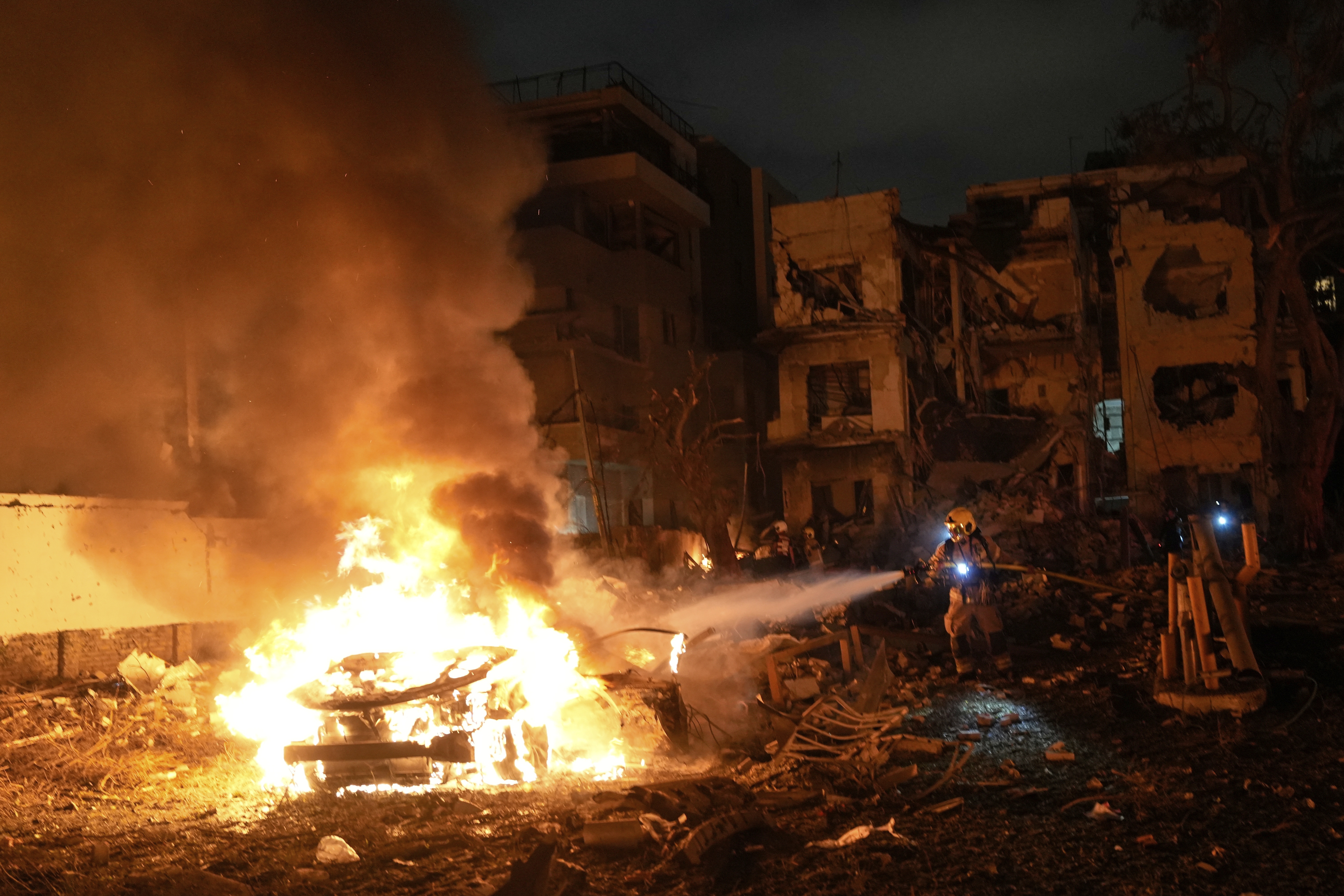 Firefighters work to extinguish a blaze after a missile launched from Iran struck Tel Aviv, Israel on Monday.