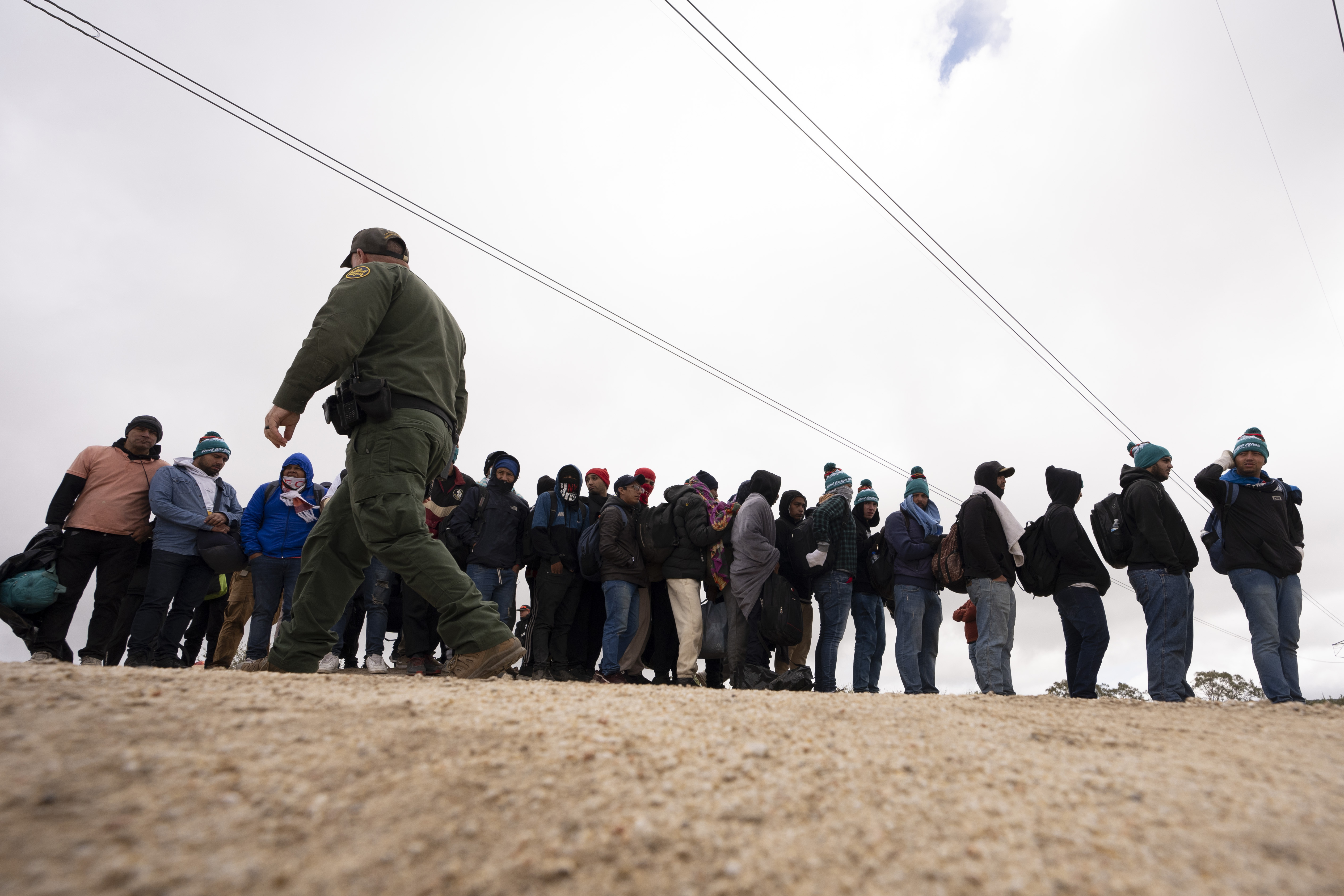 FILE - Men seeking asylum line up as they wait to be processed after crossing the border, on April 25, 2024, in Boulevard, Calif.