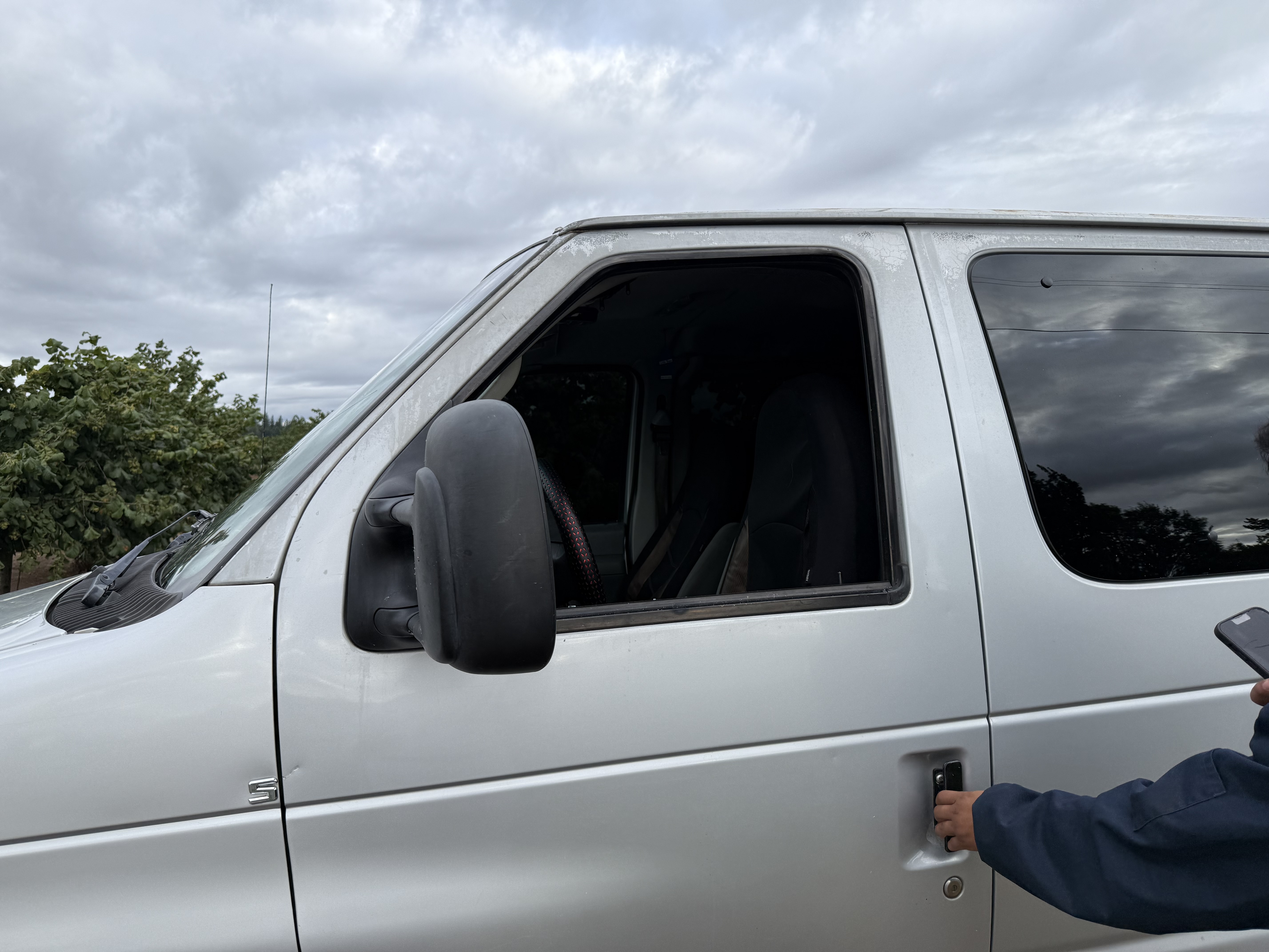 The driver's side window of a van is broken after ICE agents arrested four farmworkers on their way to work on Aug. 7, 2025, according to attorneys. Farmworker advocates say the arrest is the largest immigration enforcement action in the area this year.