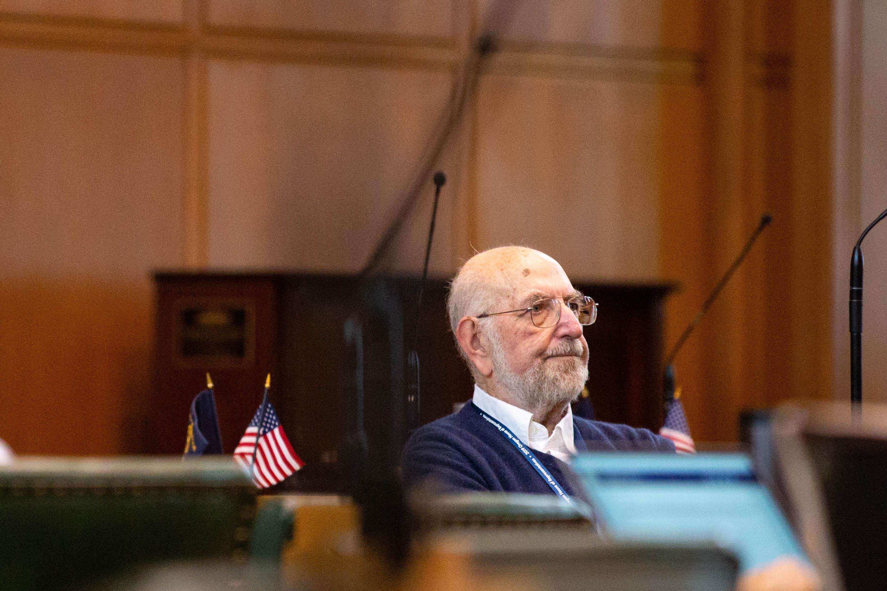 Rep. Mitch Greenlick, D-Portland, sits at a desk on the House floor at the Capitol in Salem, Oregon.