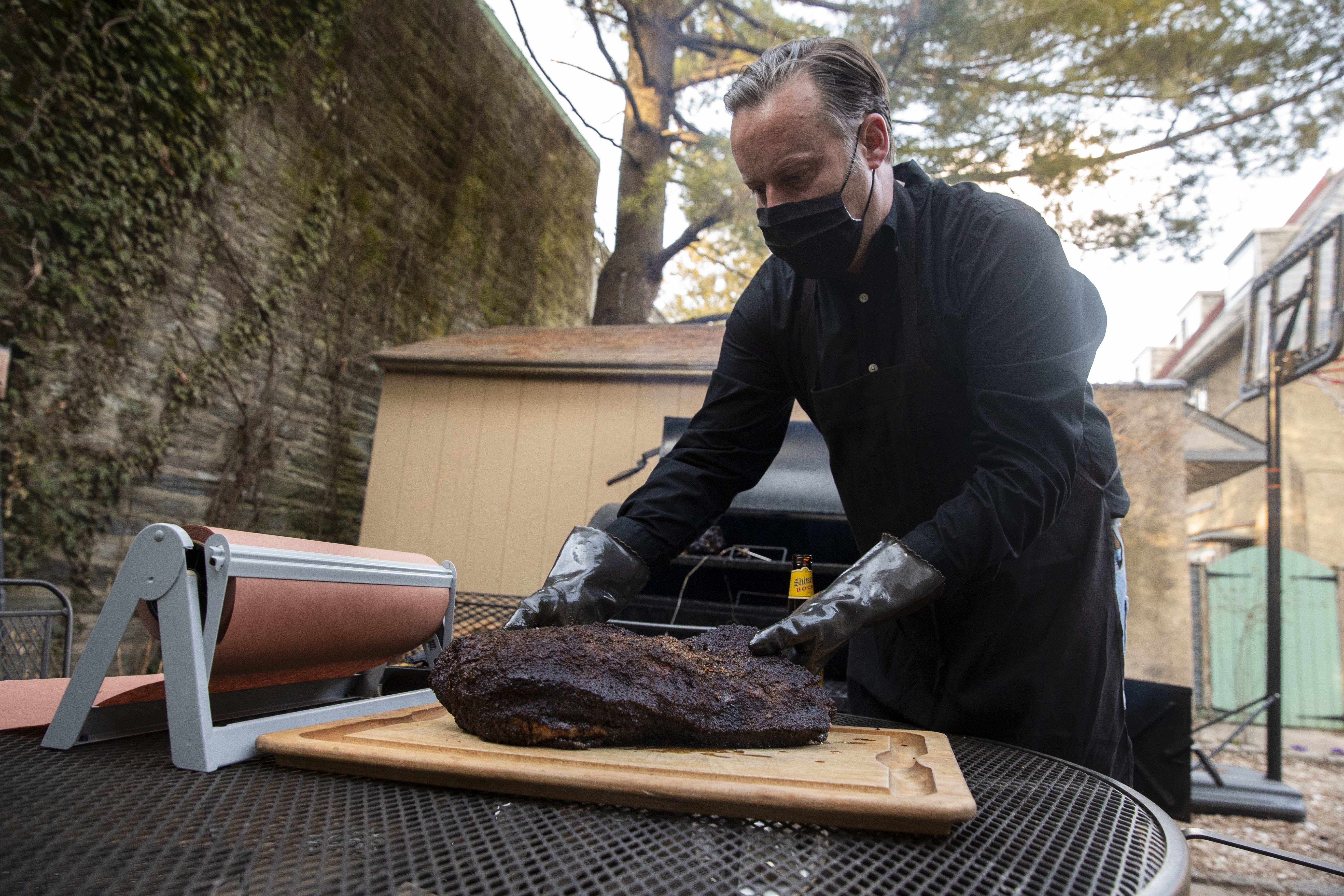 Scott Hanson places a whole brisket on a cutting board in his backyard in the Chestnut Hill neighborhood of Philadelphia, Pa. on Sunday, March 14, 2021. Scott Hanson, a history and social justice professor, is launching a weekly pop-up collaboration with Cadence that starts March 21.