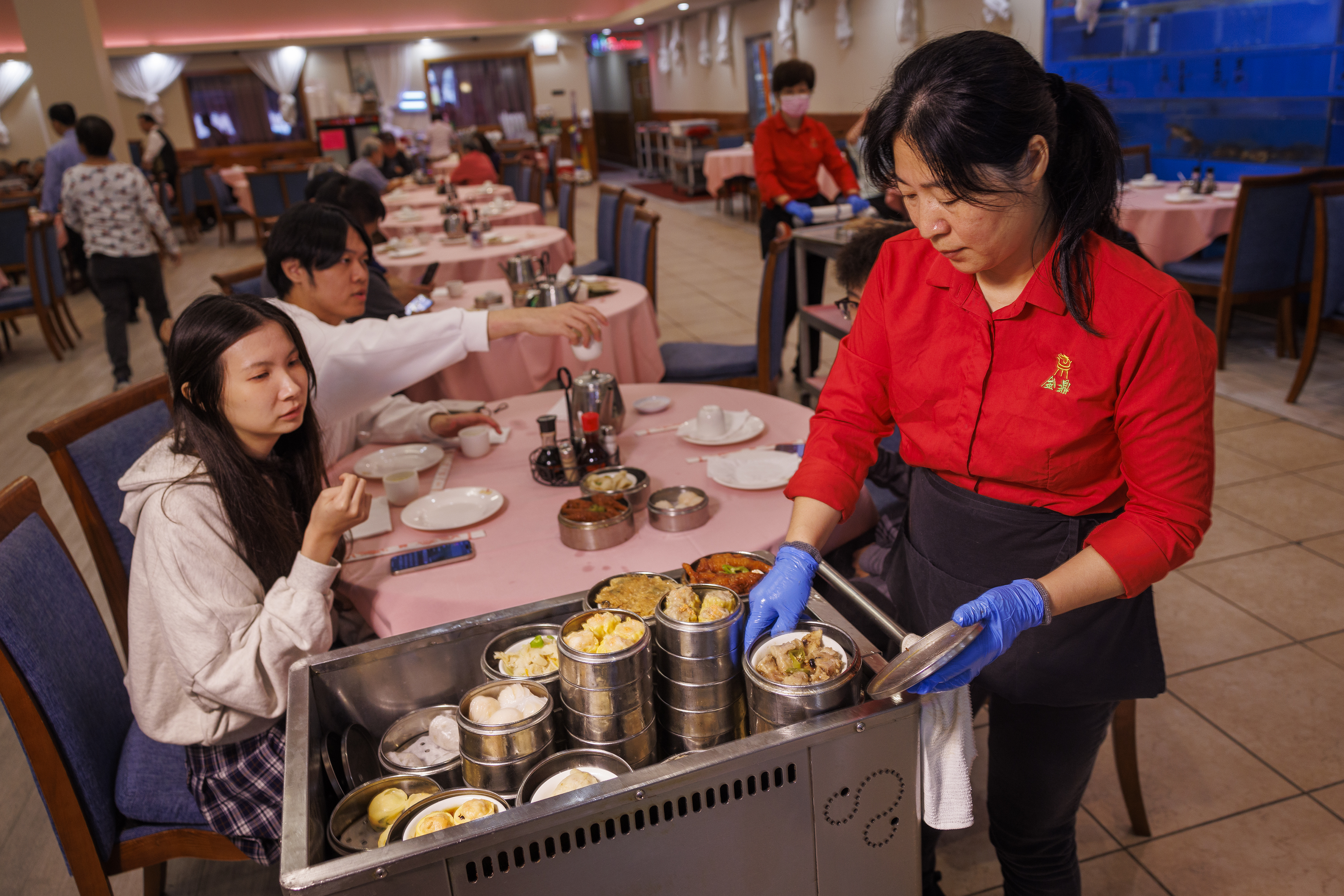 Jing Li with Dim Sum cart distributing food to customers in the dining room. China Gourmet, 2842 St. Vincent Street, Philadelphia on Friday, October 27, 2023.