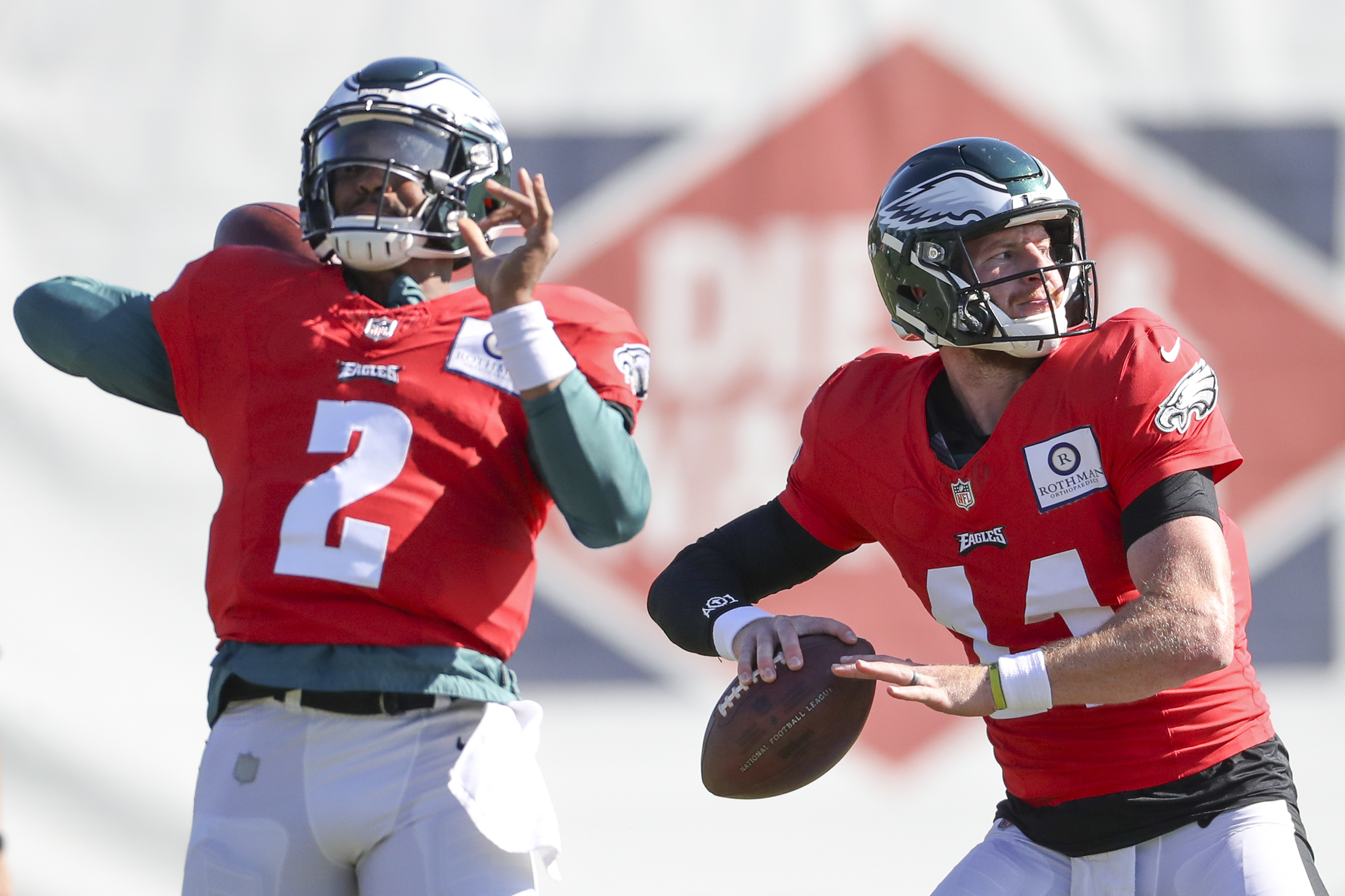 Philadelphia Eagles' Jalen Hurts, right, poses with the fan who received  his signed practice jersey with her two twins during practice at an NFL  football training camp, Sunday, July 30, 2023, in