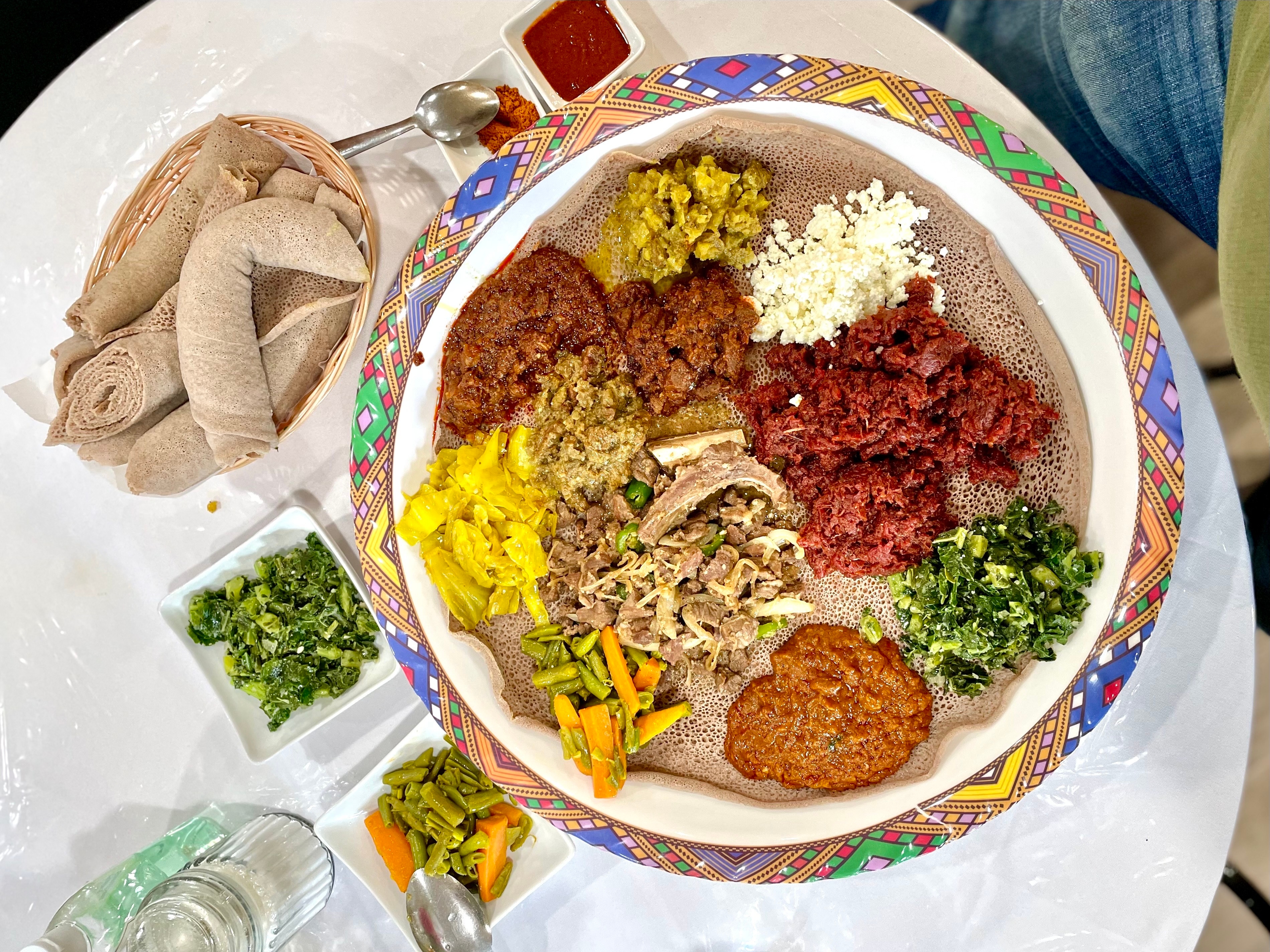 A platter of traditional Ethiopian dishes at Amsale Cafe in West Philadelphia includes, clockwise from bottom center, kitfo and cottage cheese, gomen collard greens, shiro wot, lamb qey wot, cabbage, beef alcha, beef awaze, lamb tibs awaze, lamb tibs alcha.