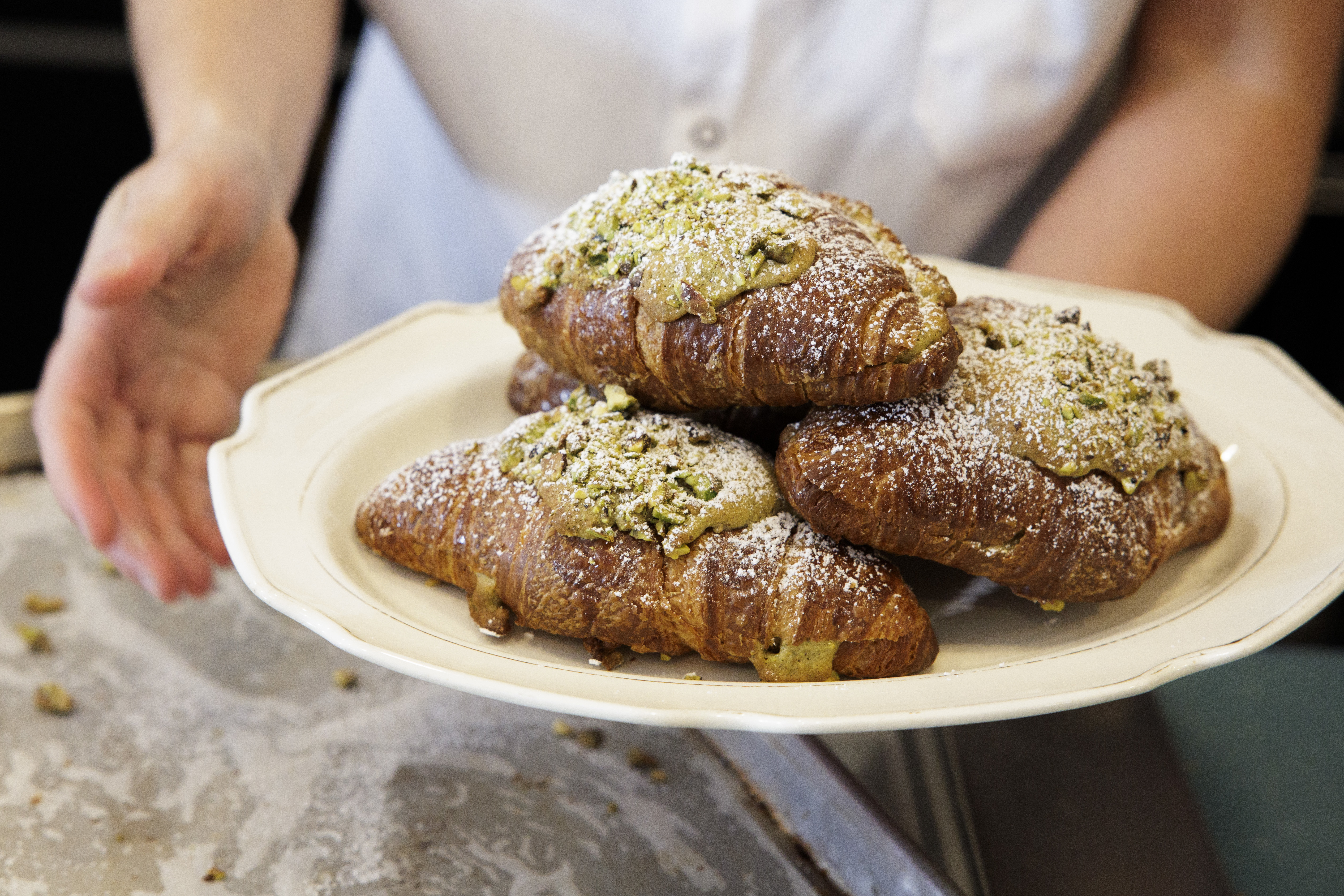 Pastry Chef/Owner Justine Macneil plates pistachio cornetti at Fiore Fine Foods in Philadelphia on Thursday, Aug. 29, 2024.