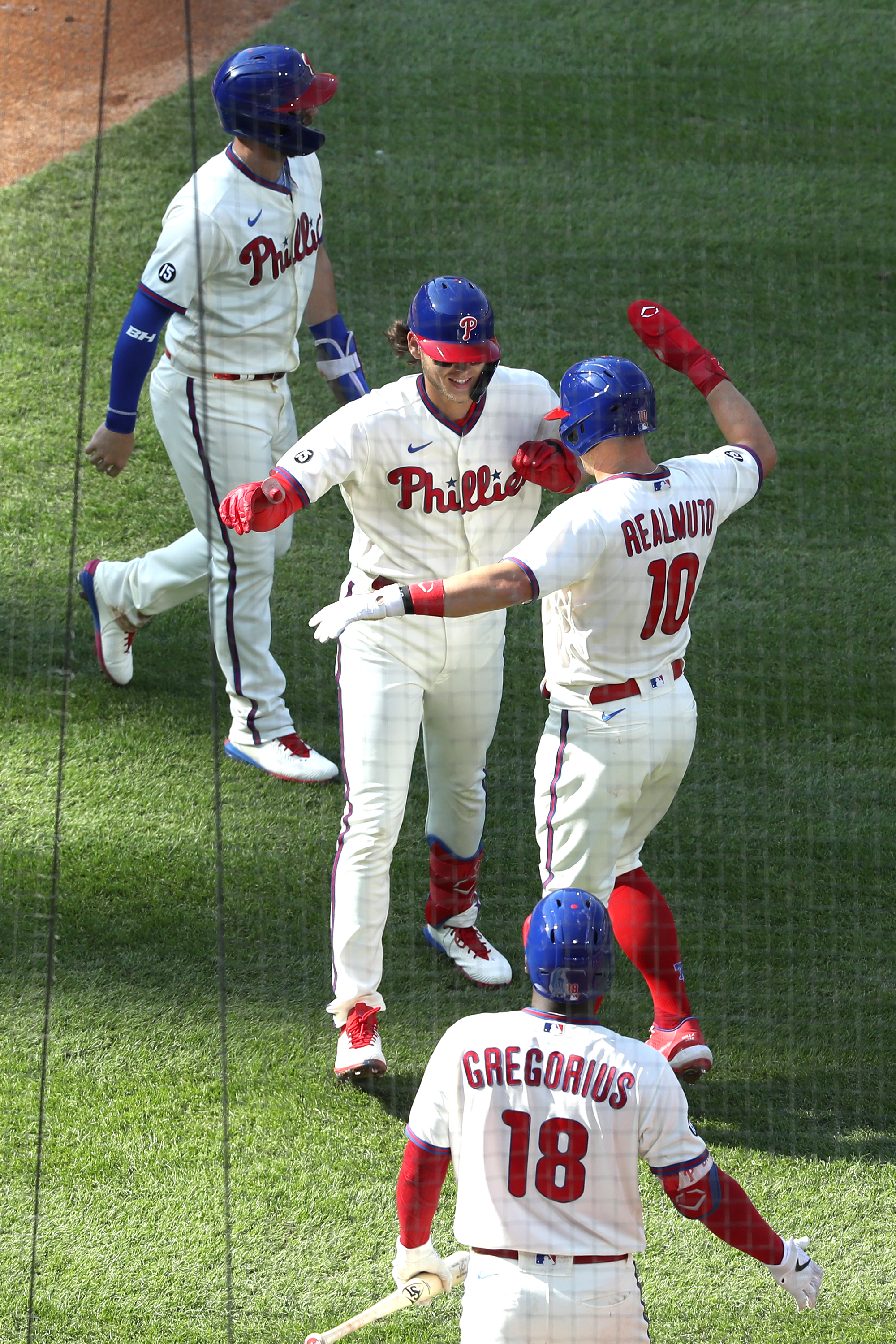 Philadelphia Phillies - Bryce Harper, Alec Bohm, J.T. Realmuto, and Rhys  Hoskins celebrating in the win line after the game. All are wearing the cream  Phillies uniform.