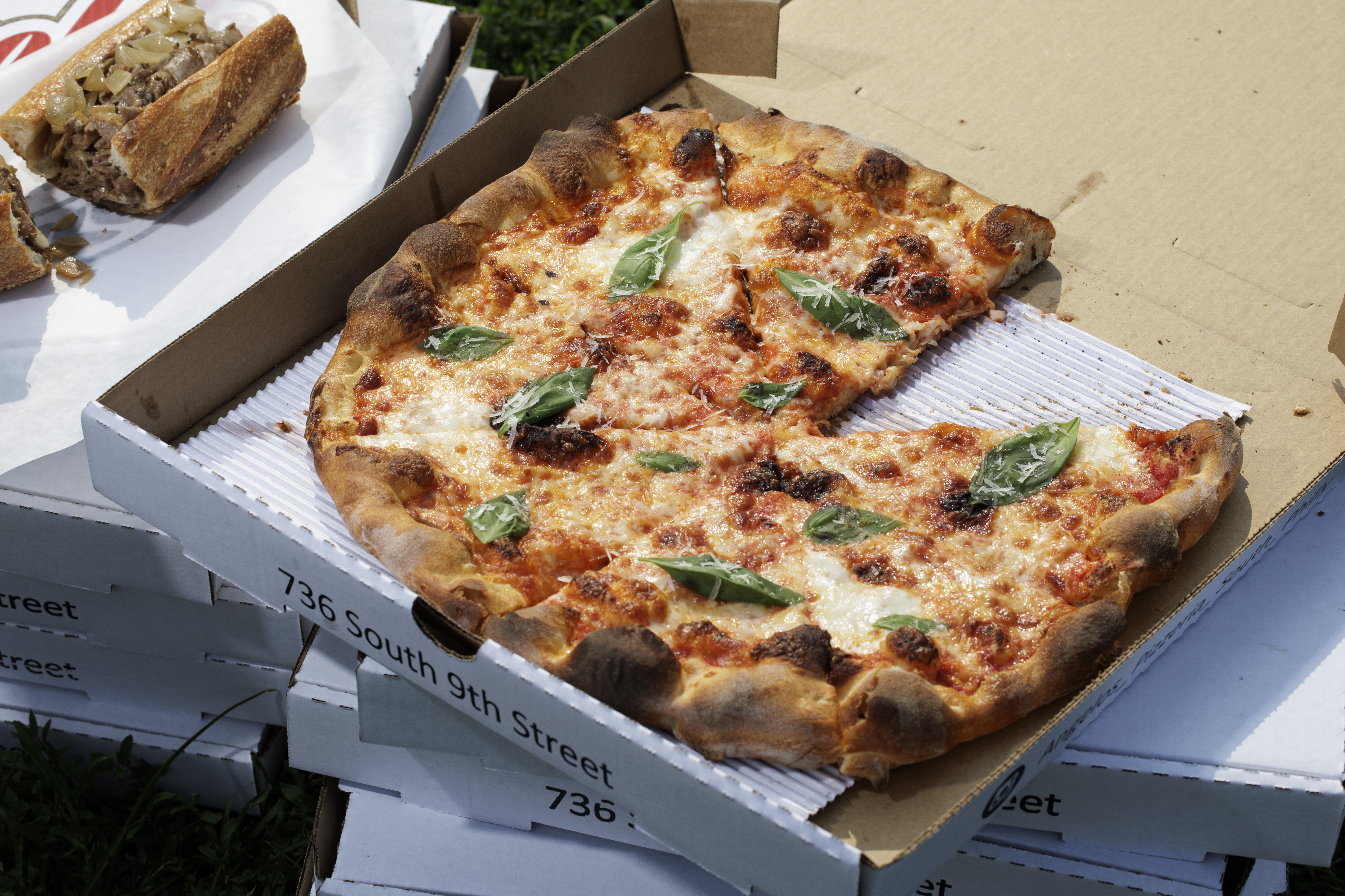 A cheesesteak and a cheese pizza near Angelo’s in Philadelphia on Thursday, Aug. 15, 2024. Food Styling by Emilie Fosnocht