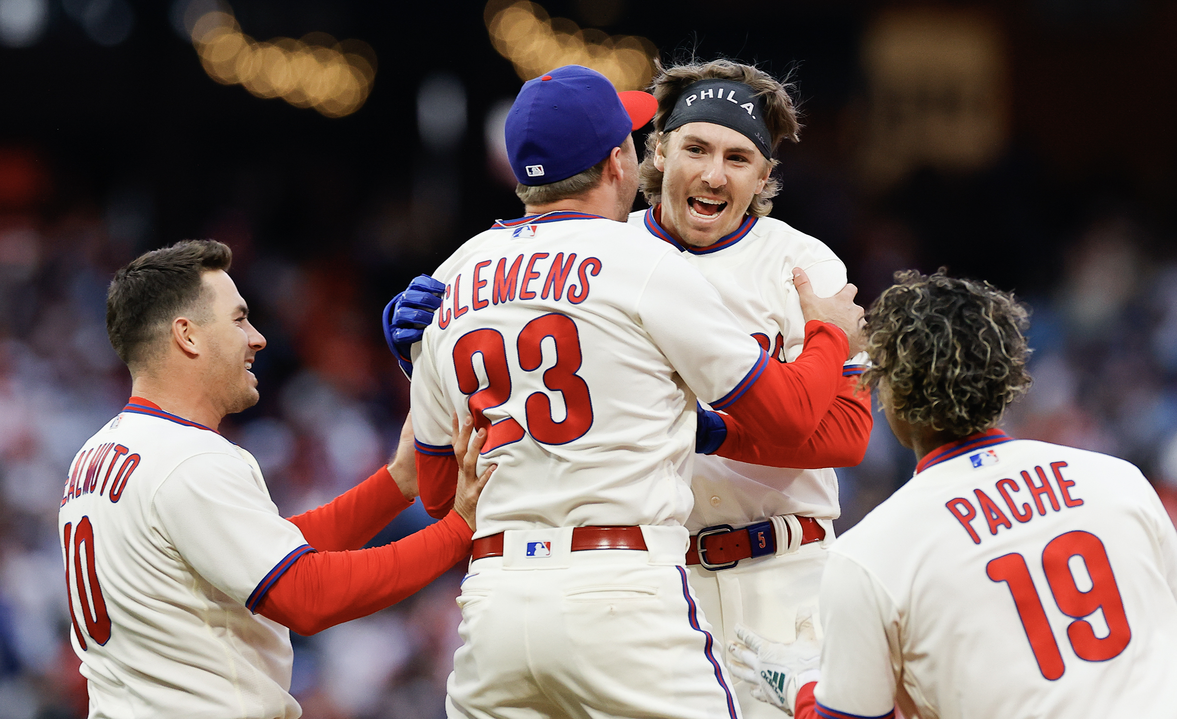 The Philadelphia Phillies' Bryson Stott gets a ceremonial water bath from  teammates Kyle Schwarber and Nick Castellanos after Stott's walk-off single  to defeat the Cincinnati Reds, 3-2, at Citizens Bank Park on