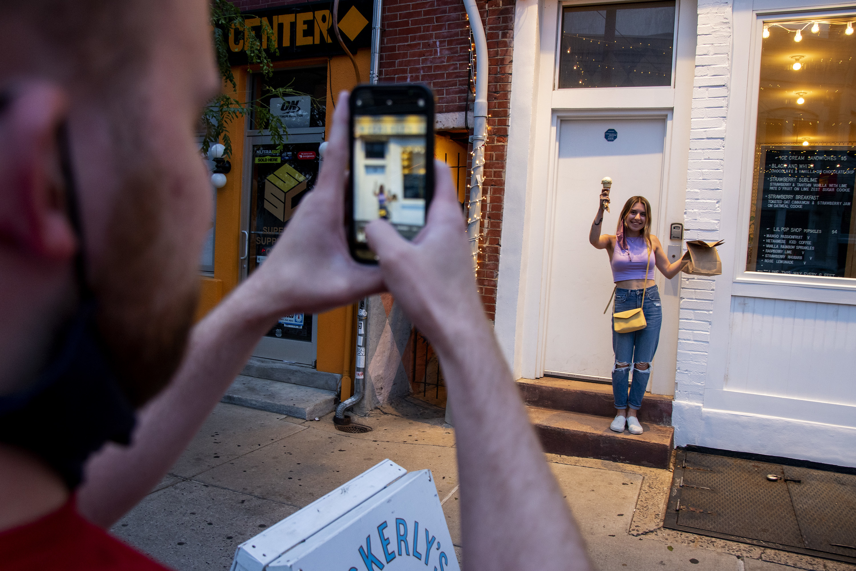 Craig Rounsaville takes a photo of Courtney Arce with her cone at Weckerly's Ice Cream in Fishtown.
