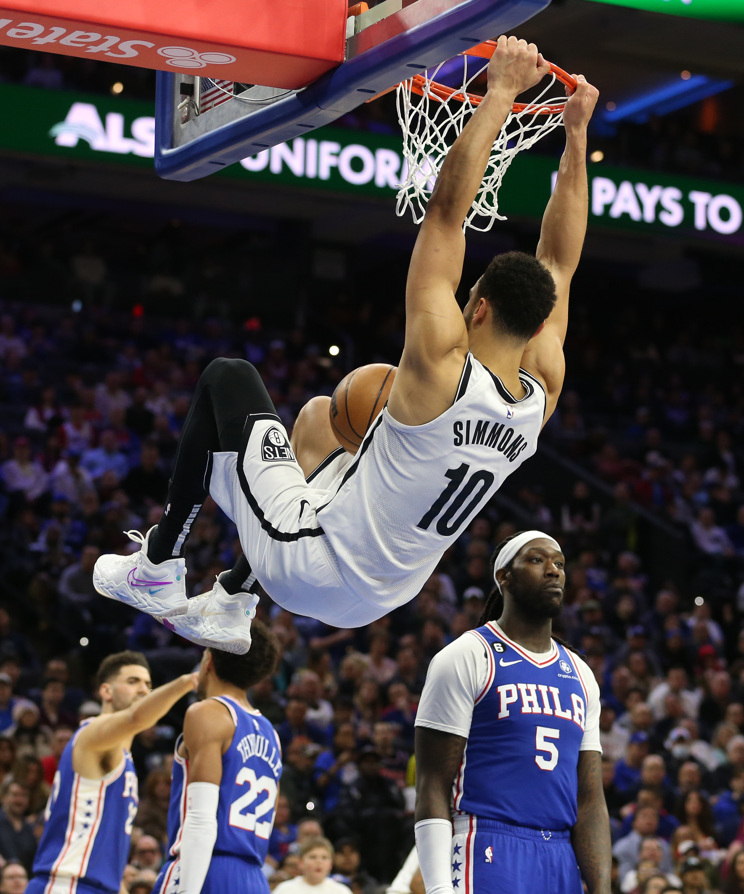 Brooklyn Nets' Ben Simmons, left, dunks as Philadelphia 76ers