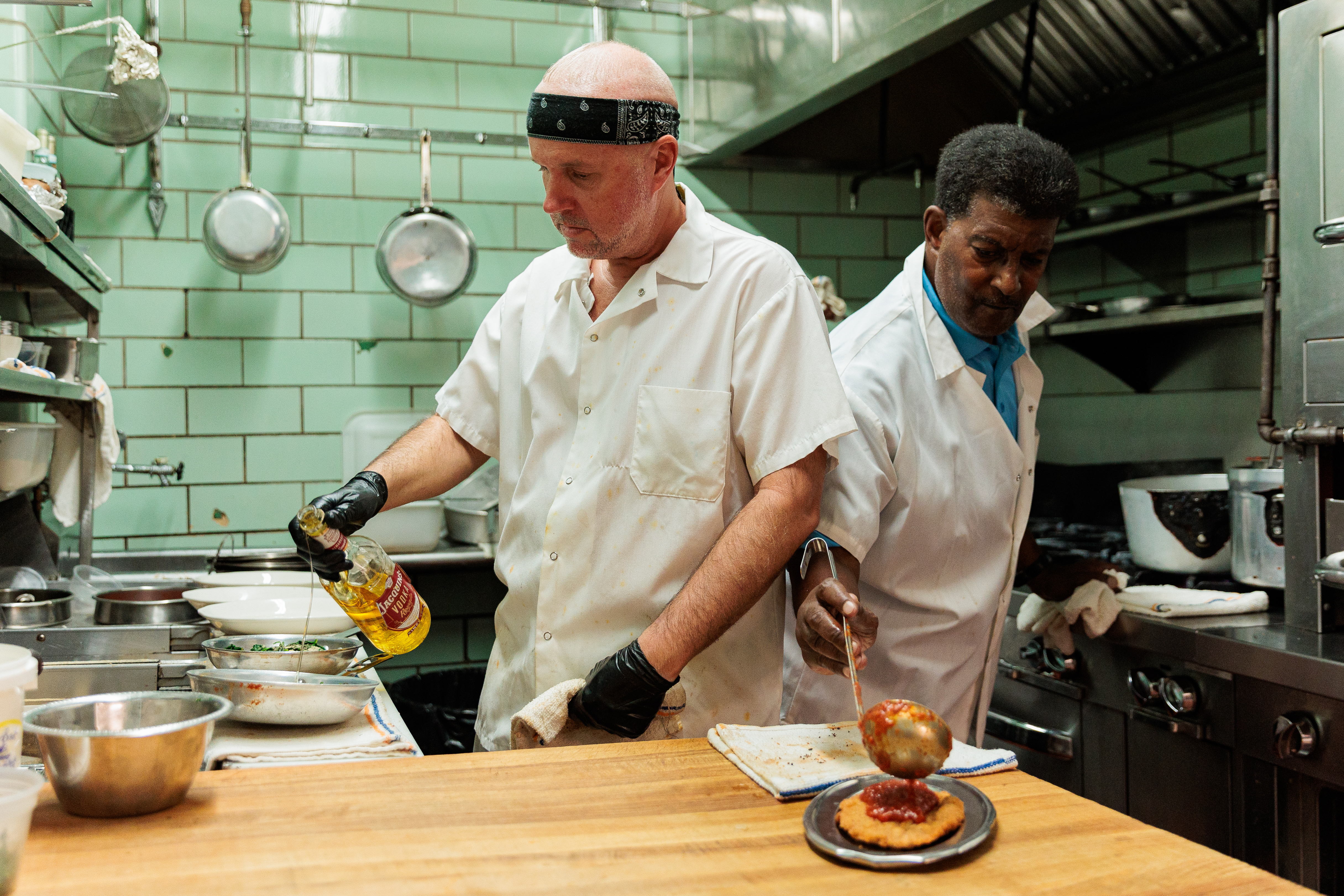 Brian Conway, left, adds vodka to a pan as Mike Daniels, right, sauces a plate at Villa Di Roma on Wednesday, Sept. 11, 2024, in Philadelphia .