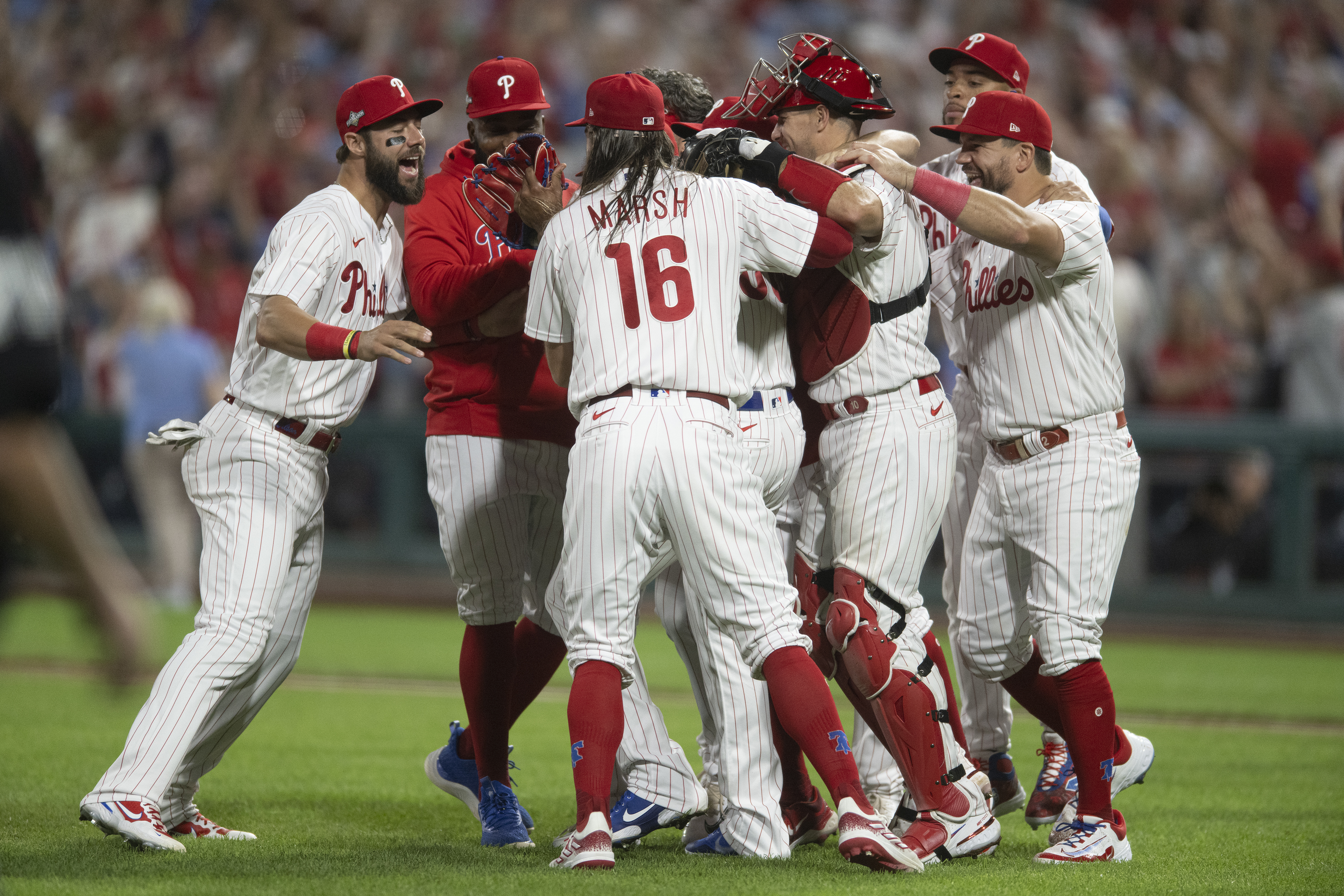 Philadelphia Phillies - The team celebrating winning today's game. They are  wearing white Phillies uniforms and hugging Bryson Stott.