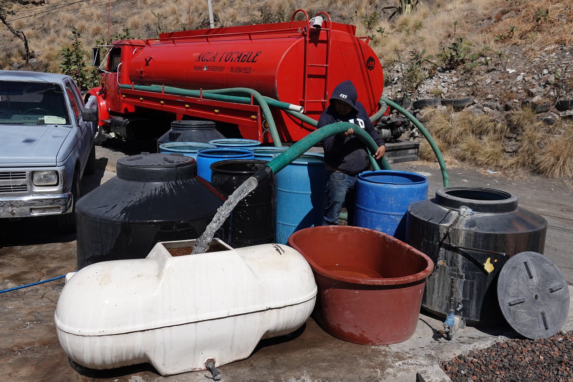 Un señor que transporta agua potable en una pipa