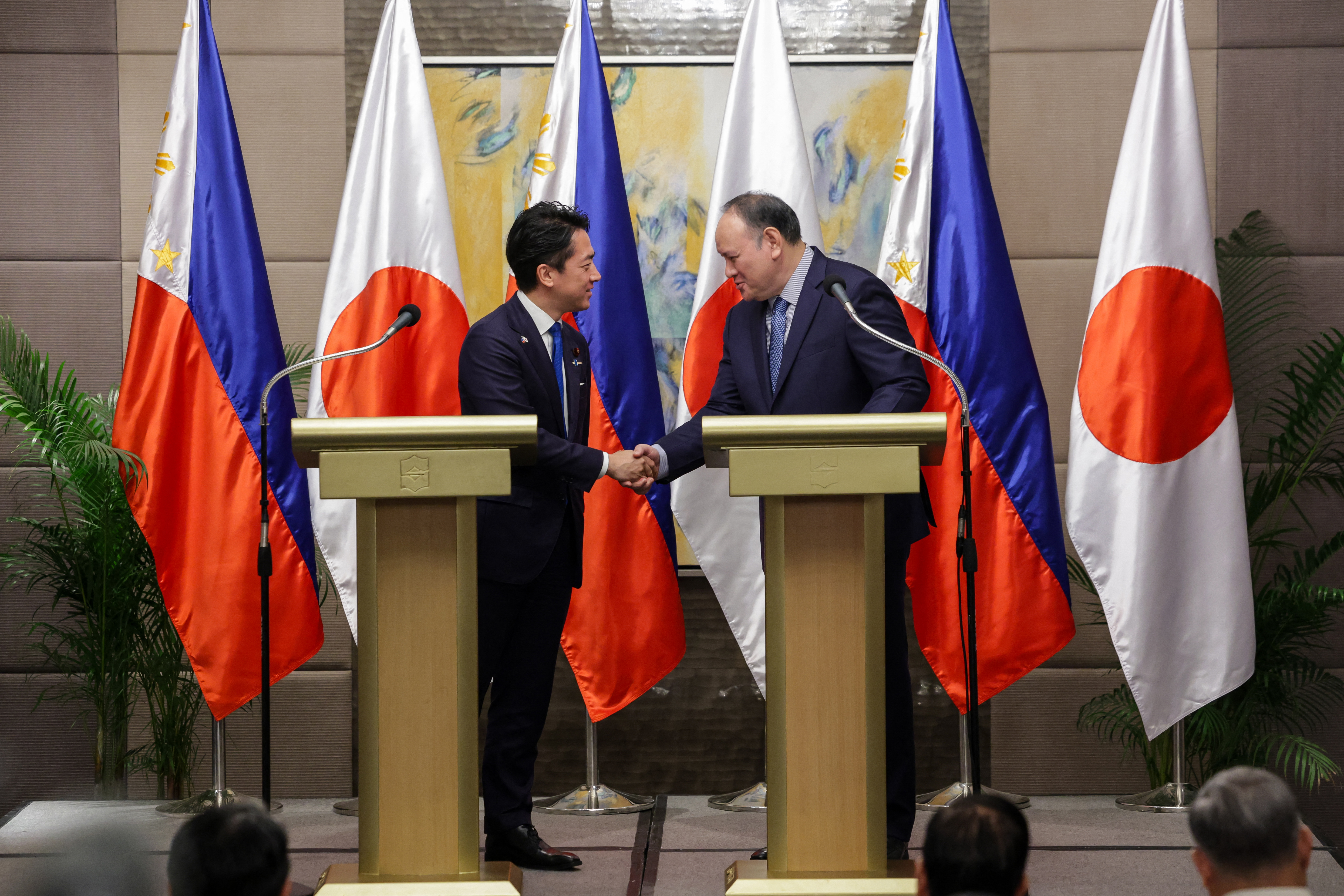 Japan's Defense Minister Shinjiro Koizumi, left, and the Philippines' Defense Secretary Gilbert Teodoro Jr., right, shake hands after a bilateral meeting in Manila, May 5, 2026.