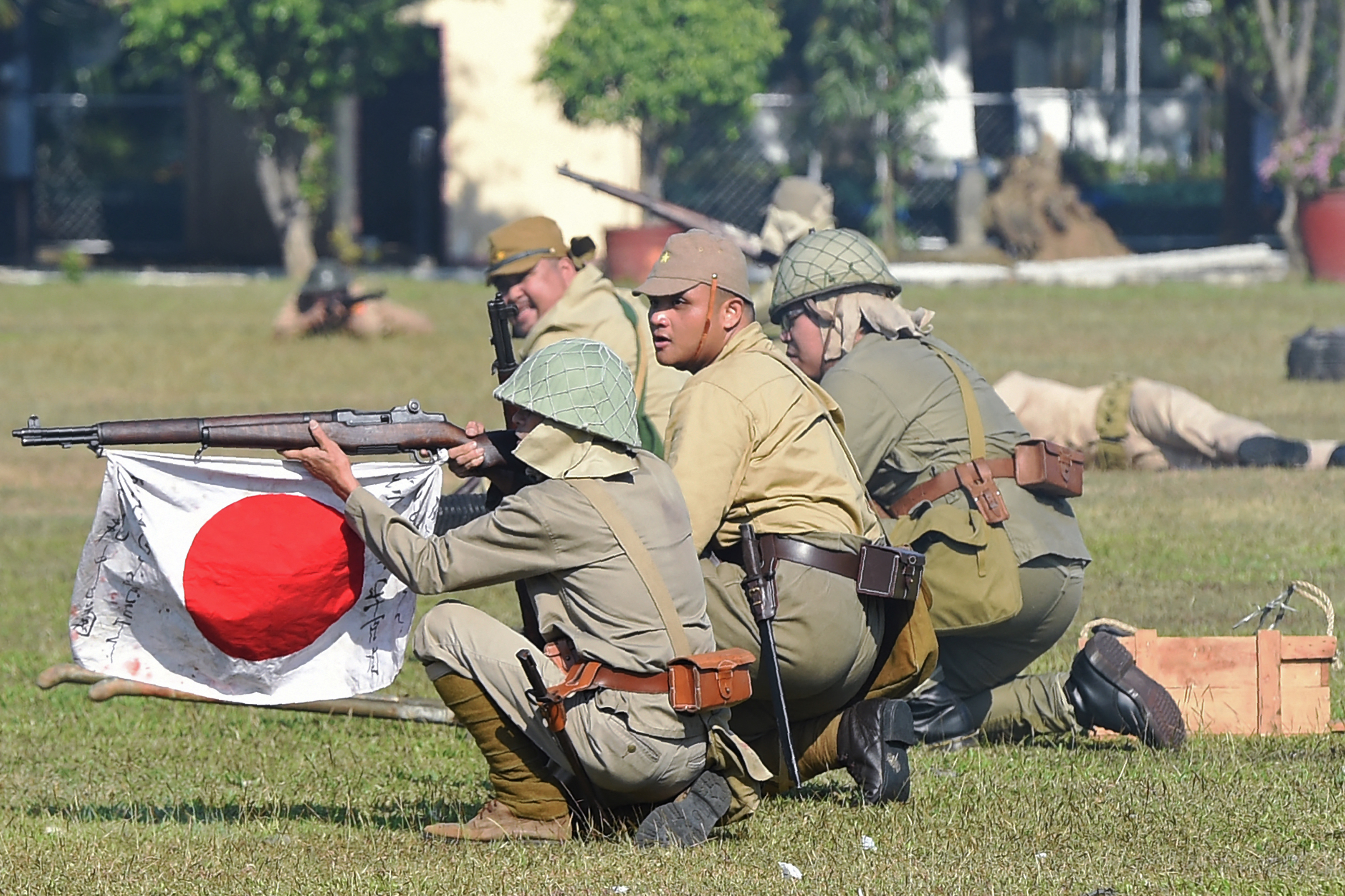 Members of the Living History Society, acting as Japanese soldiers, re-enact a scene of the "Battle of the Pockets" between allied and Japanese forces during World War II, at Camp Aguinaldo in Manila on March 25, 2017.