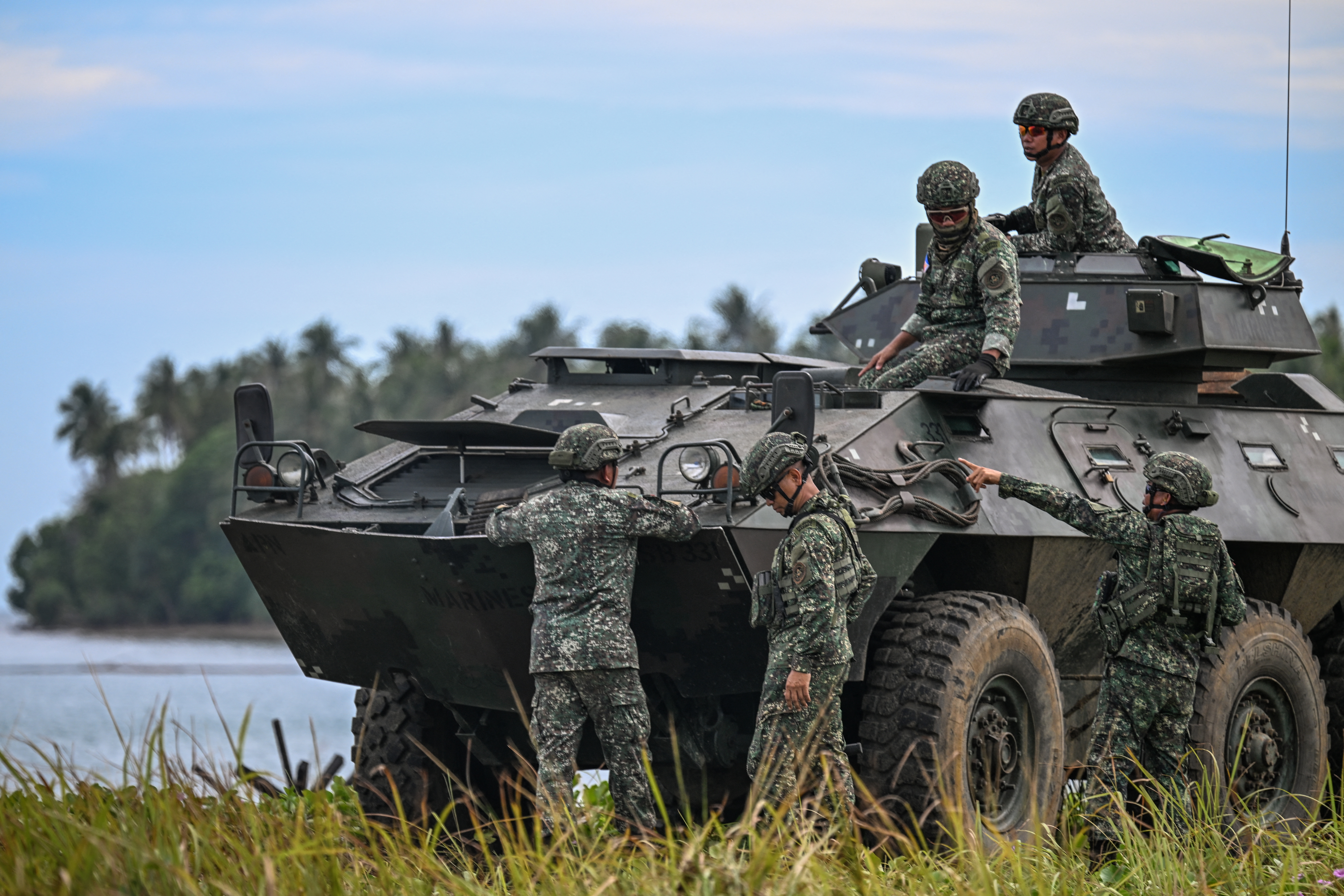 Philippine military servicemen are seen by an armored personnel carrier as they take part in a counter-landing live fire exercise during the annual US-Philippines joint military "Balikatan" exercise in Rizal, Palawan, Philippines, April 28, 2025.