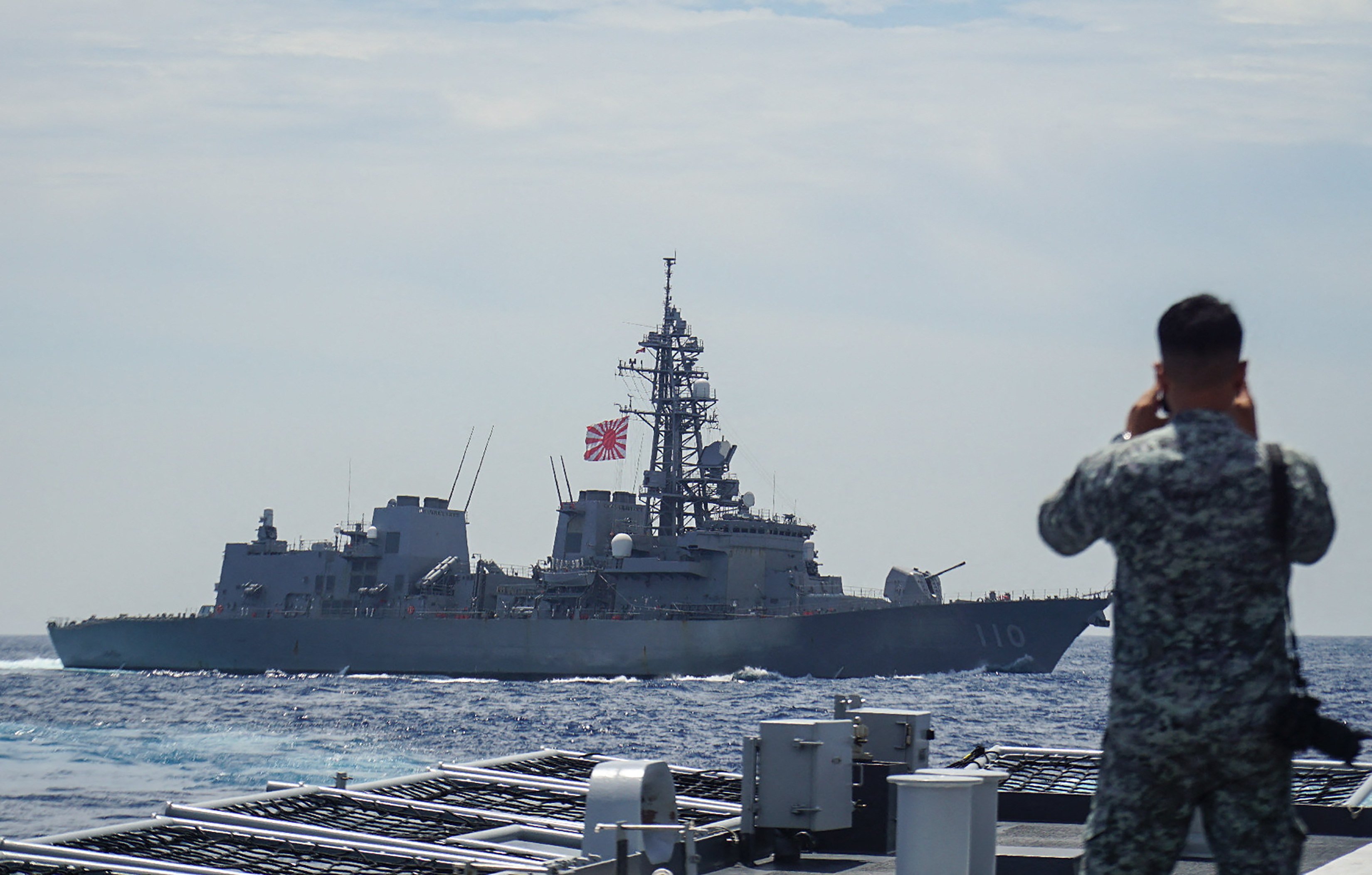 A member of the Philippine Navy looks out at the Japan Maritime Self-Defense Force's destroyer Takanami during a joint maritime exercise in the South China Sea on June 14, 2025.