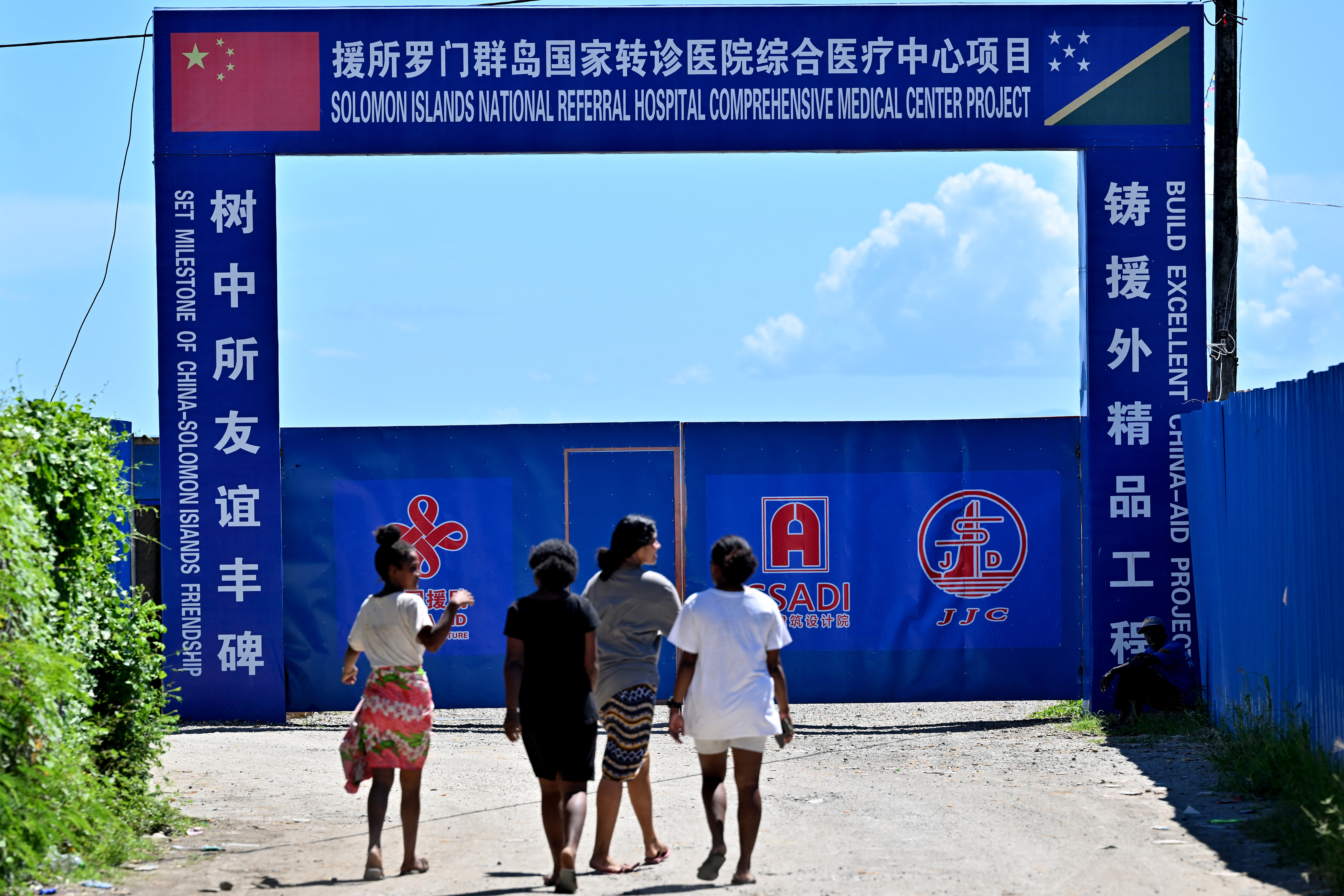 Youth walk past an under-construction medical center financed by the Chinese government, in Honiara, Solomon Islands, April 21, 2024.