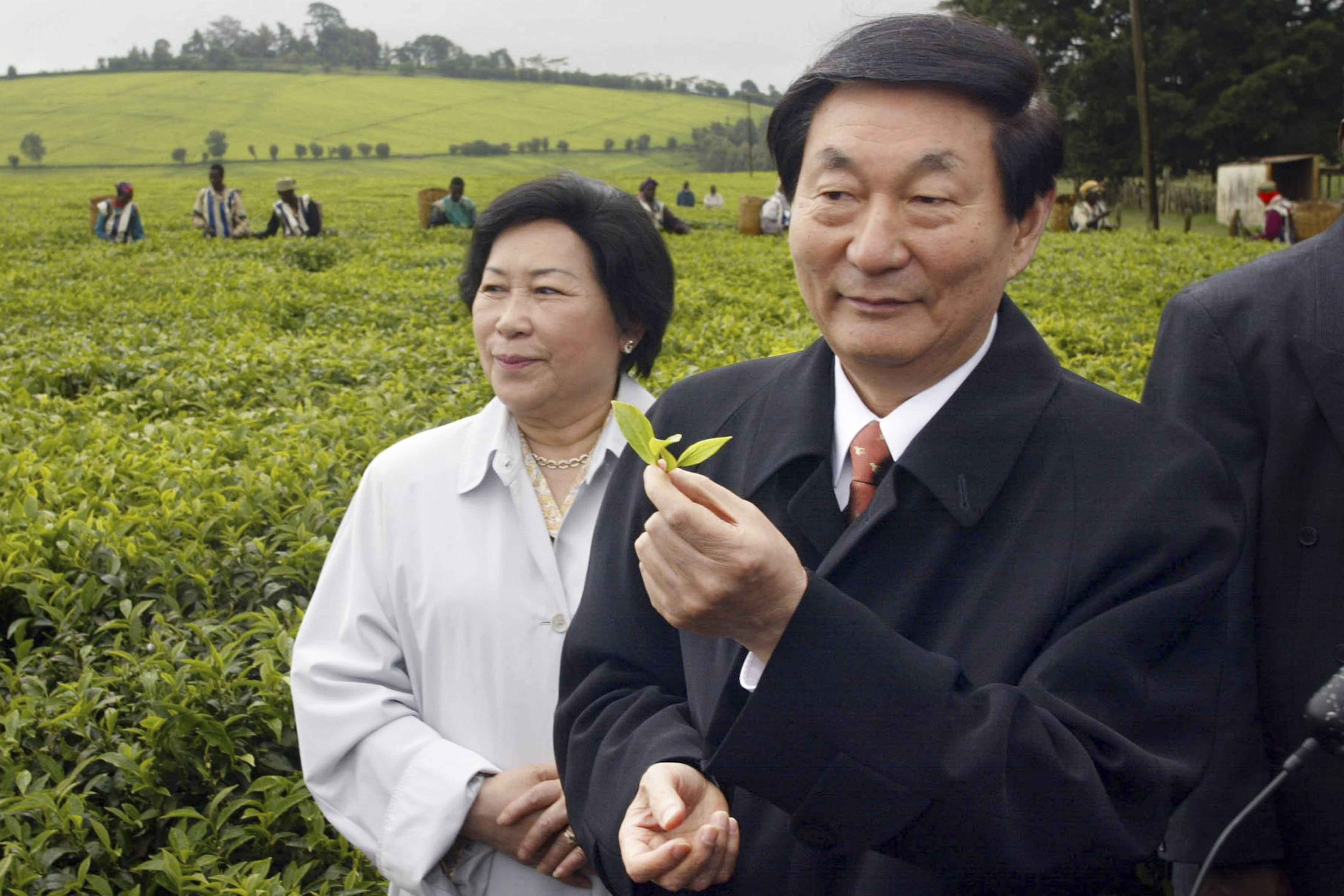 Zhu Rongji holds a tea leaf during his visit to the Maramba Tea Estate in Limuru, west of Nairobi, Kenya, April 26, 2002.