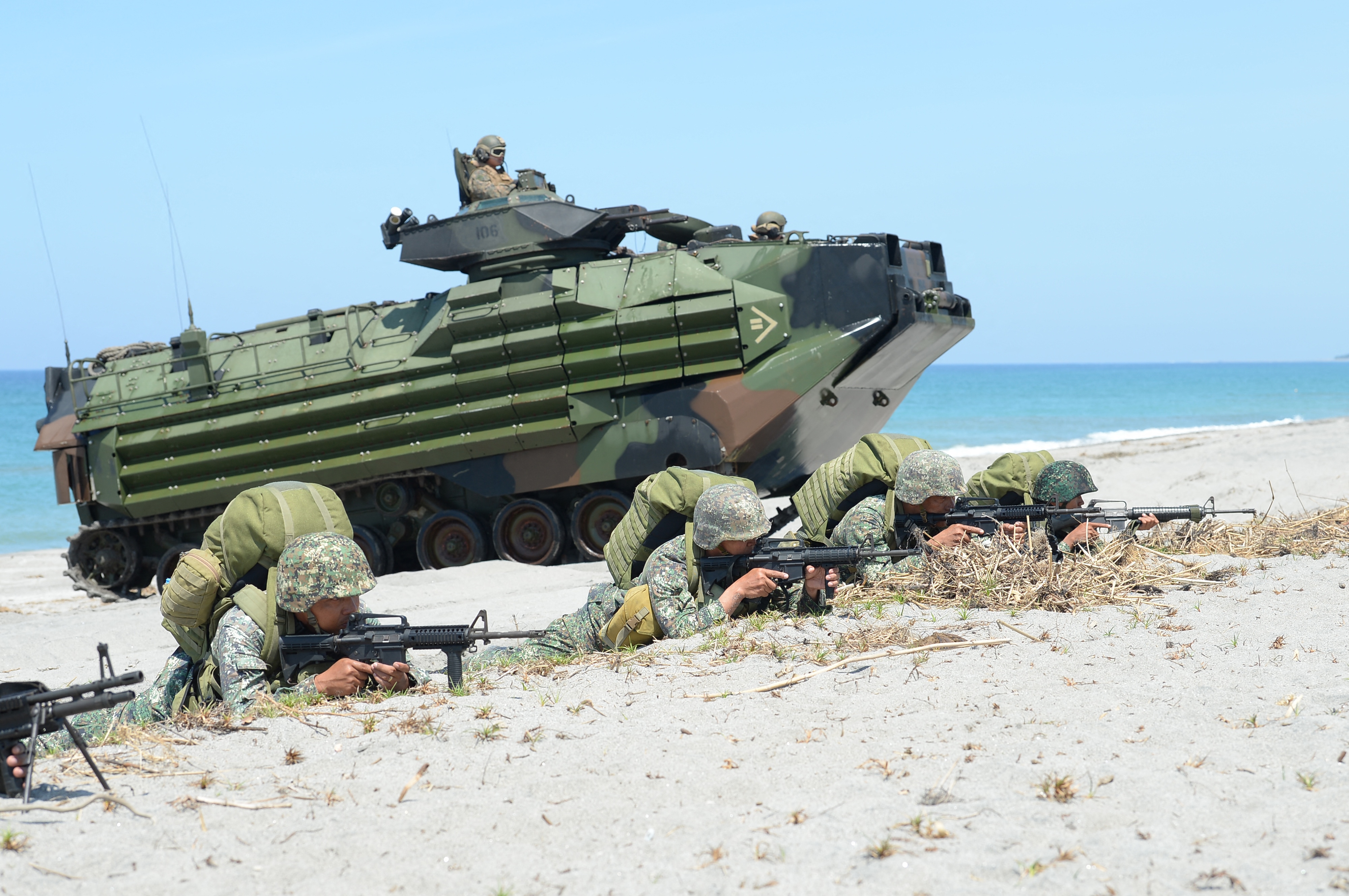 Philippine marines take position next to U.S. amphibious assault vehicles during an amphibious landing exercise at the beach of the Philippine navy training center facing the South China Sea in San Antonio, Zambales province, Philippines on Oct. 6, 2018.