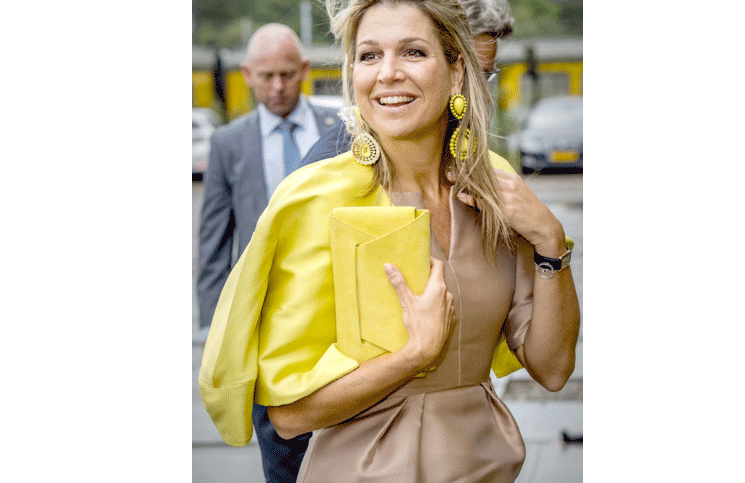 Máxima con su clutch amarillo haciendo juego con la campera