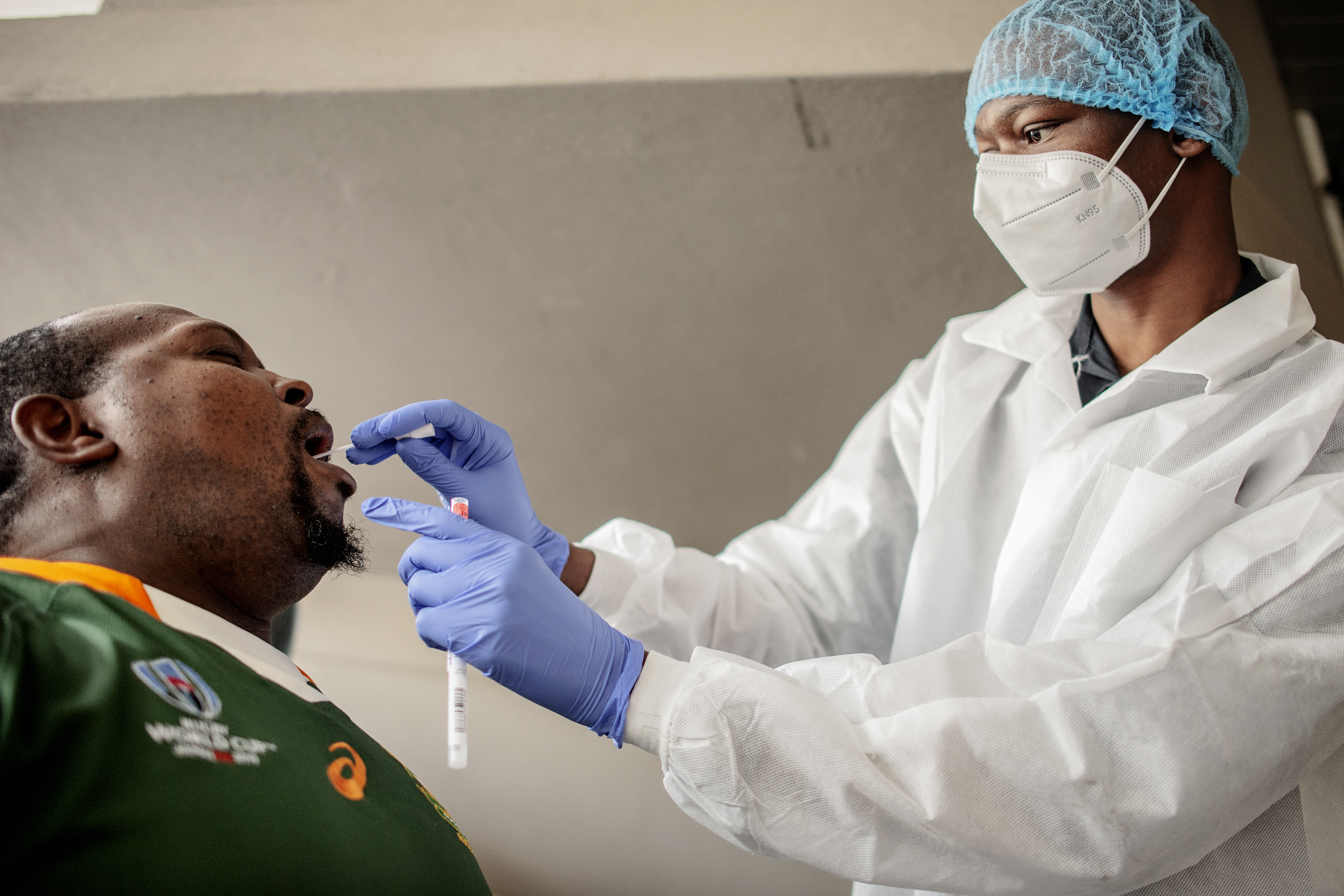 A nurse from Lancet Nectare hospital (R) performs a COVID-19 coronavirus test in Richmond, Johannesburg, on December 18, 2020. (Photo by LUCA SOLA / AFP)
