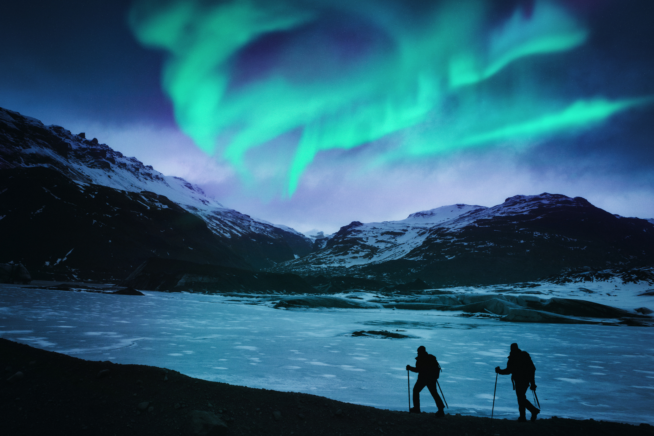 Excursionistas bajo la aurora boreal en Islandia
