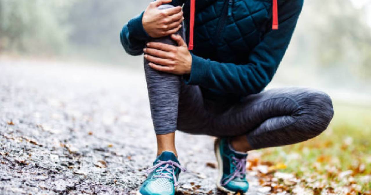 Foto de referencia de mujer haciendo ejercicio y con dolor en su rodilla.
