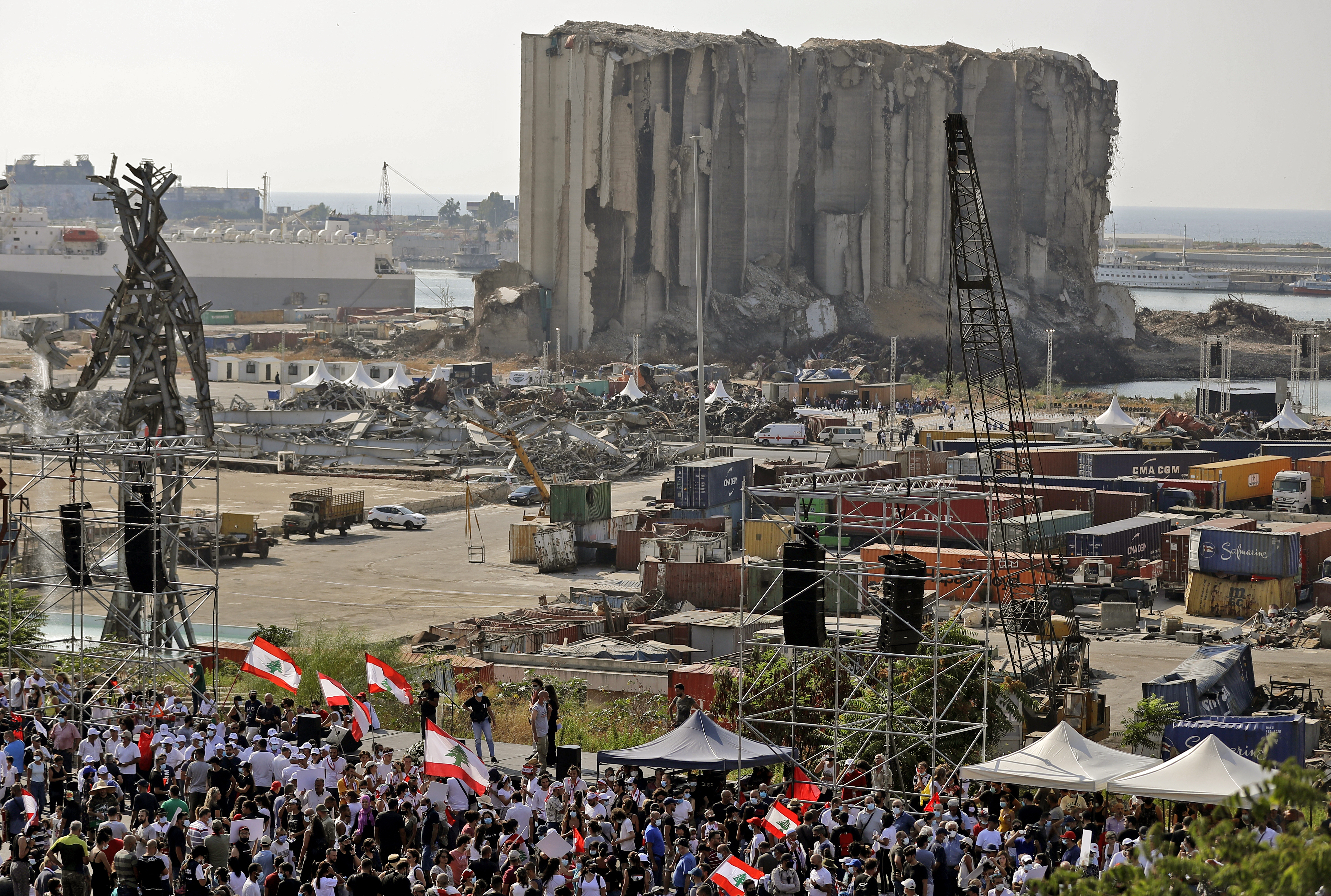 Demonstrators gather near the damaged grain silos outside the port of Lebanon's capital Beirut on August 4, 2021, on the first anniversary of the blast that ravaged the port and the city. - Hundreds of Lebanese marched on August 4 to mark a year since a cataclysmic explosion ravaged Beirut, protesting impunity over the country's worst peacetime disaster at a time when its economy was already in tatters. (Photo by JOSEPH EID / AFP)
