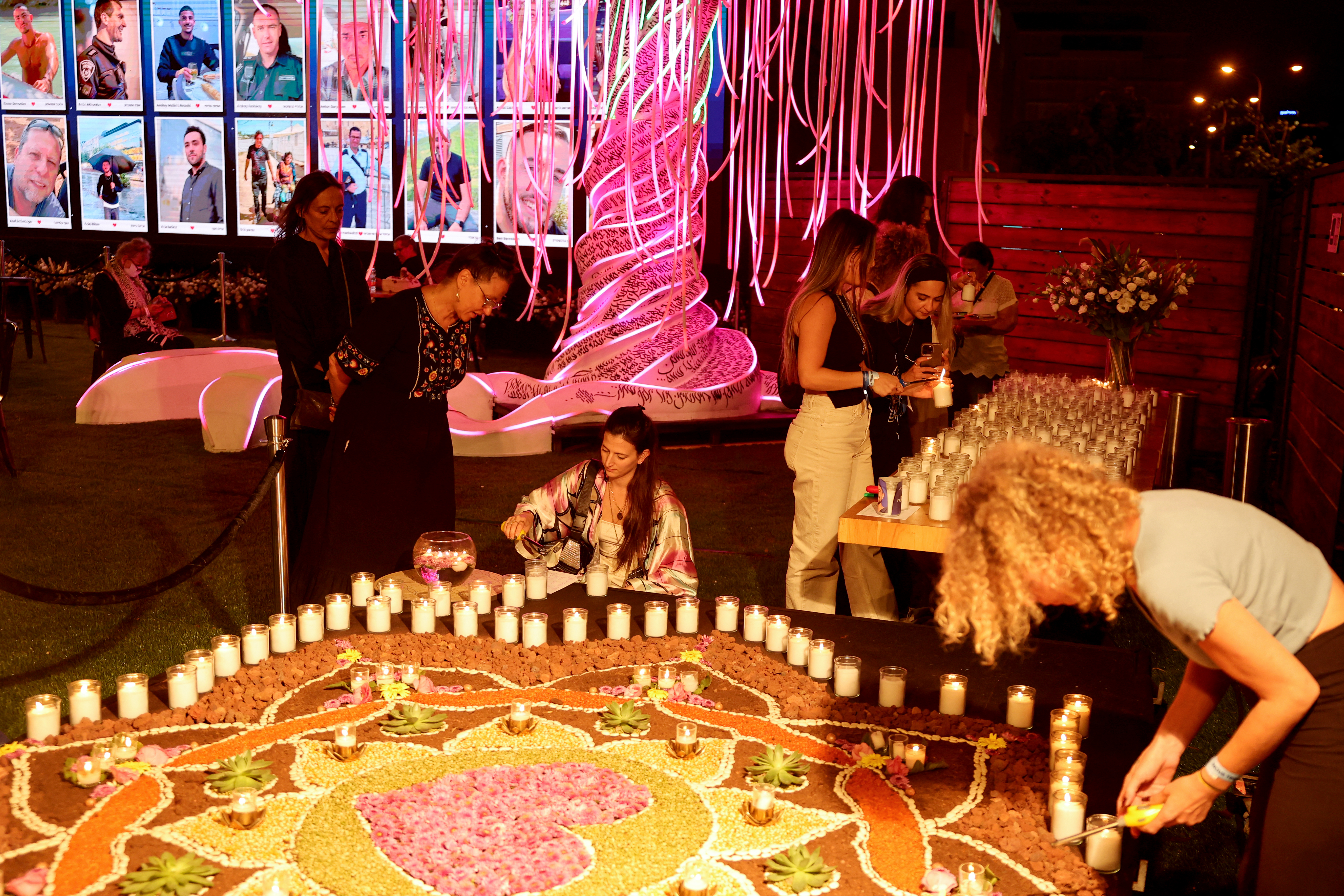 People light candles at a memorial for the victims killed at or kidnapped from the Supernova music festival during the October 7 attacks by Palestinian militants, on the eve of the attacks' first anniversary in Tel Aviv on October 6, 2024. The anniversary comes as fears mount that the war against Hamas is tipping into a wider regional conflagration. Israel has been pounding the Lebanese capital Beirut, as its troops fight Hezbollah fighters in Lebanon's south. (Photo by JACK GUEZ / AFP)