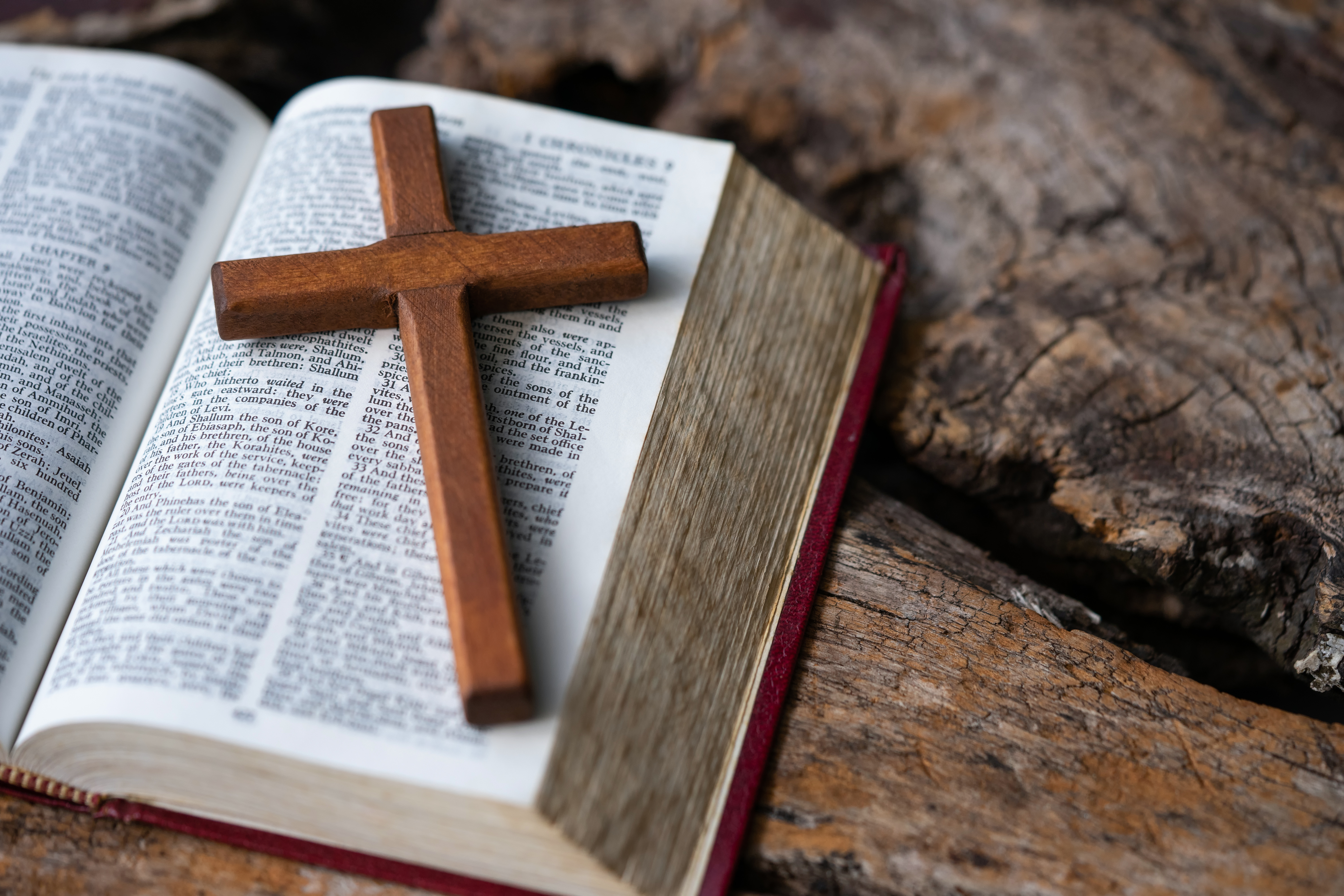 Wooden cross, Holy Bible on table